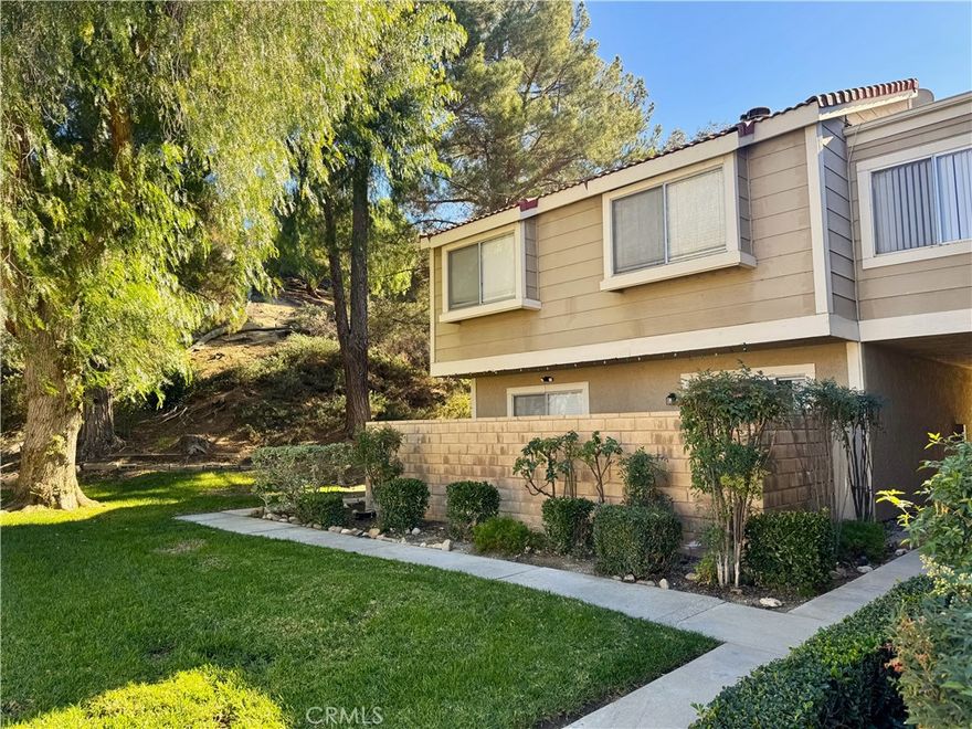 Discover your private retreat in Cimarron Oaks—this secluded end-unit condo sits quietly at the back of the community, offering serene views of the lush greenbelt filled with mature trees and foliage. Step outside to your own private patio, the perfect spot for barbecues and gatherings with family and friends. This inviting home features 3 bedrooms and 2.5 baths across two spacious levels, complete with a detached two-car garage. Inside, the lower level showcases McMillan Luxury Waterproof SPC Flooring for both elegance and durability, while the vaulted ceilings in the primary bedroom create an airy, expansive feel. Ideally located near shopping, dining, and close access to the interstate 5 freeway. Cimarron Oaks combines comfort with accessibility. Don’t miss the chance to call this hidden gem your new home—a sanctuary of modern living surrounded by natural tranquility.