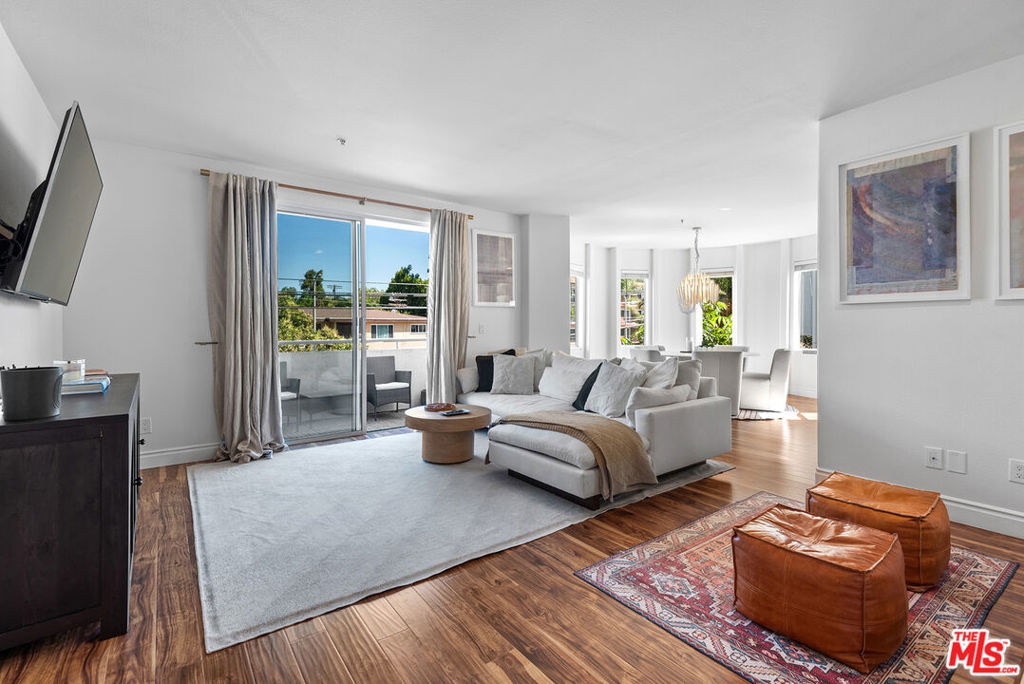 Welcome to this beautifully updated single-story corner unit in the sought-after Park Place Vistas community. This bright and airy 2-bedroom, 2-bathroom condo offers an abundance of natural light, thanks to its expansive windows, and effortless indoor-outdoor living with two private balconies. Step into a spacious living room featuring engineered wood floors, a cozy fireplace, and an adjacent unique circular dining area framed by windowsan ideal space for entertaining or quiet evenings at home. The chef-inspired kitchen is outfitted with stainless steel appliances, granite countertops, a custom backsplash, a wine fridge, and its own window for added light and ventilation. The generous primary suite is a true retreat, featuring a massive walk-in closet, access to a private balcony, and a spa-like ensuite with dual vanities. A well-proportioned second bedroom and an updated full bathroom complete the thoughtful layout. Additional highlights include central air and heat, in-unit laundry, and two-car parking. Park Place Vistas is an intimate community of just 16 residences, offering a peaceful setting with a sparkling pool and spa and open green space perfect for relaxing.