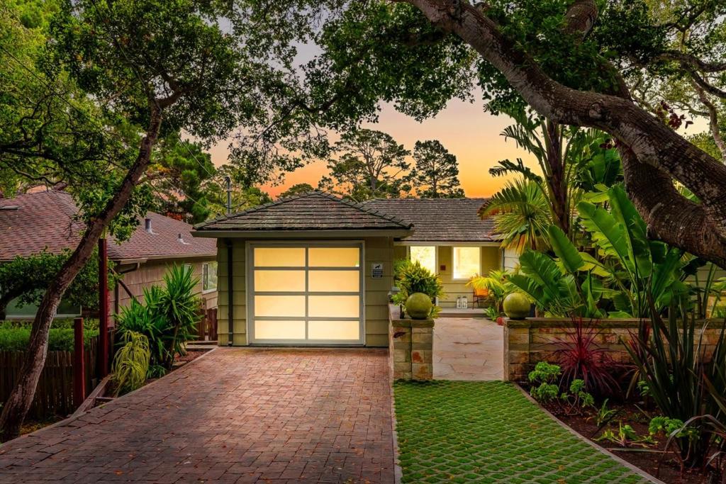 Tucked away just a few blocks from downtown Carmel-by-the-Sea, this beautifully reimagined coastal retreat offers the perfect balance of privacy, scale, and style. Set behind lush tropical landscaping, the home lives like a private sanctuary while still being moments from world-class restaurants, shops, and white sand beaches. Thoughtfully redesigned from the ground up, the residence features approximately 1,800 square feet of light-filled living space with radiant heated floors, surround sound, and an open-concept layout ideal for modern living. The kitchen is a showpiece, with a large marble central island, clean-line cabinetry, and stainless appliances, flowing seamlessly into the vaulted great room with a striking marble-wrapped fireplace. The spacious primary suite includes a generous walk-in closet and spa-inspired bath. Larger-than-average bedrooms are a rare find in Carmel, offering comfort and flexibility for guests or family. Multiple outdoor living areas from the secluded courtyard to the sun-drenched upper deck make it easy to relax, entertain, or simply enjoy views of Point Lobos in the distance. Whether you're looking for a full-time residence or a weekend escape, this is a turn-key opportunity in one of Carmels most coveted neighborhoods.