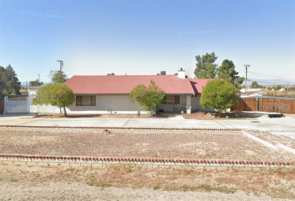 Welcome to this beautiful sanctuary - an inviting single-story home located in the highly desirable Desert Knolls neighborhood. Step inside to find the beautifully decorated main living areas with a winery theme that adds charm to the atmosphere. The formal living room features a cozy wood-burning stove, perfect for creating a warm ambiance. The fully equipped kitchen includes essential appliances such as a gas range, dishwasher, microwave, refrigerator, and a trash compactor, making meal preparation a breeze. This home boasts a practical split floor plan with the primary suite conveniently situated near the attached two-car garage. Enjoy meals in the spacious formal dining room and take advantage of the large laundry room. The abundance of cabinet space ensures excellent storage solutions. A standout feature of the property is the expansive enclosed sunroom patio, which leads out to a covered patio and a generously sized backyard. The backyard offers drive-thru gates on both sides, providing easy access. For year-round comfort, the home is equipped with HVAC. Additionally, for hobbyists, there is a sizable metal shop available for an extra $300 per month. This property welcomes your birds and chickens. Garden shed not available at this time. Renters Insurance Required