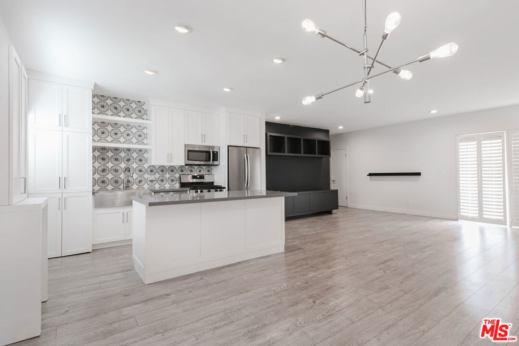 Bask in abundant natural light from morning to late afternoon in this newly renovated, TOP-FLOOR 2-bedroom, 2-bathroom condo, perfectly positioned in a coveted West Hollywood location just north of the iconic Laurel Hardware restaurant. Set within a chic Mid-Century building, the open and airy layout is enhanced by sun-drenched interiors, creating a warm, inviting atmosphere throughout the day. The gourmet kitchen features sleek quartz countertops, a handcrafted tile backsplash, and premium stainless steel appliances, along with the convenience of an in-unit washer/dryer. Both bathrooms have been luxuriously remodeled with in-shower seating, and premium stainless steel fixtures for a spa-inspired feel. Spacious bedrooms offer a serene retreat with designer wallpaper and authentic grasscloth accents for a blend of modern elegance and timeless style. Step onto the expansive covered patio to enjoy peaceful courtyard views framed by lush greenery and a classic kidney-shaped pool. Additional perks include a generously sized storage closet. With Whole Foods, trendy restaurants, and vibrant nightlife all just moments away, this home embodies the best of West Hollywood living in one of its most desirable spots.