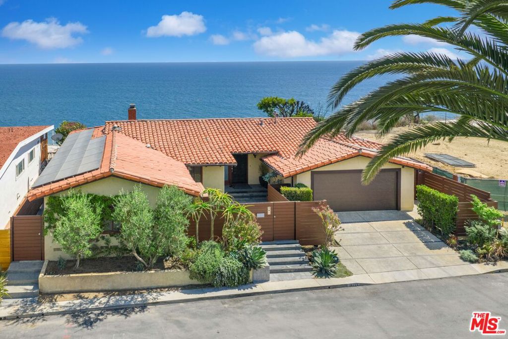 Sunset Mesa Front Row Bluff Estate With Sweeping Ocean Panoramas. Perched directly above the Pacific, this approx. 2,299 sq ft 3 bed/2 bath residence offers head-on views from Catalina to the Queen's Necklace. Walls of NanaWall glass open to expansive terraces and a grassy bluff-top yard, creating an outdoor living experience so immersive it feels as if you are floating on the ocean itself. An entertainer's dream, the outdoor space features a jacuzzi spa overlooking endless horizon views, wood-fired pizza oven, built-in Sol Gourmet grill, Lynx refrigeration, pergola dining, and firepit lounge. Inside, vaulted ceilings and a sleek fireplace anchor the open living areas. The chef's kitchen is equipped with Viking 6-burner cooktop, GE Monogram ovens and refrigerator, Bosch dishwasher, and Franke/Kohler sinks. The primary suite flows seamlessly to the yard, offering a spa bath with jetted soaking tub, glass shower, and walk-in closet. Smart living includes Control4 automation, Nest climate, whole-home audio, solar panels with Enphase battery storage, and Tesla charger. A finished garage with LG ThinQ laundry and custom cabinetry completes this rare offering. A true front row Sunset Mesa retreat where luxury, technology, and oceanfront living converge.