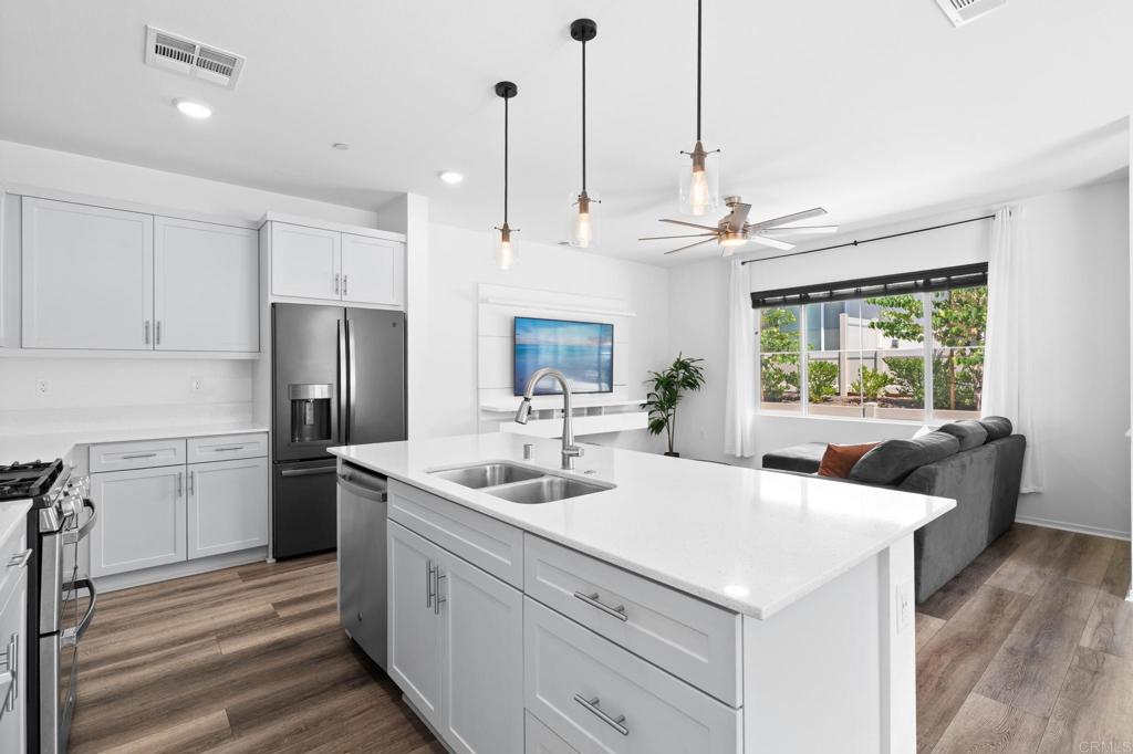 Discover modern, eco-conscious living in this practically brand-new, energy-efficient 4-bedroom, 2.5-bath townhouse at 360 Sweet Place, Fallbrook, CA 92028. Built in 2022, this 2-story end-unit townhouse shares only one wall with its neighbor, offering enhanced privacy and abundant natural light. With paid-for solar panels, you’ll enjoy significant energy savings in this move-in-ready home. The open-concept downstairs features spacious living, dining, and kitchen areas, with a large island, stainless steel appliances (stove, oven, microwave, dishwasher, refrigerator negotiable), and a convenient half bath, perfect for entertaining and daily living. Upstairs, four well-appointed bedrooms include a primary suite with a walk-in closet, ensuite bath with double sink vanity, a full guest bath, and a washer/dryer closet. Smart home capabilities like Alexa controls, automatic bathroom lights, and dimmer lights enhance the modern experience, complemented by central air conditioning and heating. The attached 2-car garage with direct access to the home provides convenience and protection from the elements for both occupants and vehicles. Located within walking distance to the dog park, pool, and clubhouse, and just off I-15 and CA-76. This home offers access to a vibrant community with a large pool, BBQs, parks, trails, and playgrounds. Steps from visitor parking and resident mailboxes, this end-unit townhouse is ideal for all, especially those seeking a low-maintenance, contemporary lifestyle in North County San Diego.