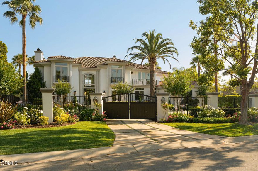 Tucked away in Camarillo's coveted Spanish Hills community and perched on the 15th fairway of the Spanish Hills Club, 1069 Corte Barroso sits on one of the best lots in the neighborhood. This grand 7,121 SF contemporary estate on a flat, lush 1-acre lot features 6 bedrooms, 6.5 bathrooms, and a fully gated entrance offering premier privacy and exclusivity. Panoramic golf course and ocean views elevate everyday living in this beautifully designed residence that blends rich textures, clean lines, and luxurious scale. A dramatic formal entry welcomes you into voluminous interiors, where a soaring great room with a stone fireplace and oversized windows creates an elegant yet inviting space for gathering. The fully renovated and expanded kitchen is a chef's dream, outfitted with paneled Sub-Zero and Asko appliances, Wolf double ovens, induction + gas cooktop, microwave, two warming drawers, a large island with breakfast bar, dining area, built-in desk, and separate scullery. Oversized windows and a wall of French doors frame the serene outdoor space, enhancing the seamless indoor-outdoor flow. Flanking the entry are formal living and dining rooms, while the true showpiece downstairs is a moody, speakeasy-style bar with mini fridges, ice machine, oversized wine fridge, and custom woodwork. The main level also includes a spacious primary suite, laundry room, and an additional bedroom converted into a stunning office with custom cabinetry. Upstairs, a second expansive primary suite offers a large sleeping area, sitting room, modern electric fireplace, and French doors that open to a private terrace with jaw-dropping 180-degree views of Camarillo, the golf course, airport, and the Channel Islands--where sunsets are a daily highlight. Three additional guest bedrooms upstairs each feature ensuite baths for optimal comfort. The entertainer's backyard features lush, meticulously landscaped grounds, a renovated pool and spa, covered patio with built-in speakers, TV lounge with fireplace, full outdoor kitchen, putting green, and separate fire pit area. With an oversized 3-car garage, Tesla wall, owned solar and water purification systems, RV parking, and a truly unbeatable location, this estate is a rare offering and an exceptional place to call home.