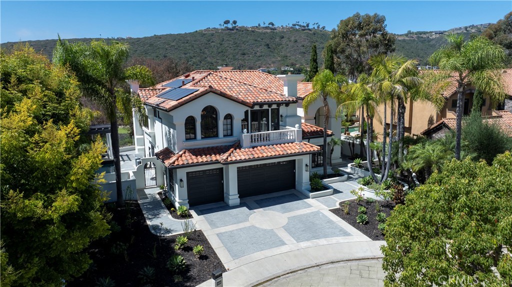 Welcome to your dream home, a masterfully remodeled Mediterranean-style residence nestled in the prestigious, guard-gated South Peak community of Laguna Niguel. Situated on a serene cul-de-sac with breathtaking views of the El Niguel Country Club golf course, rolling coastal hills, and refreshing ocean breezes, this 4-bedroom, 5-bathroom masterpiece spans approximately 4,200 square feet on a sprawling 9,000-square-foot lot. Seamlessly blending timeless elegance with modern sophistication, this light-filled retreat offers luxury, privacy, and an unparalleled Southern California lifestyle.
Step through the grand front door into a striking foyer, where high ceilings, checkerboard floors, and brass fixtures create a vintage-glam ambiance. The open-concept main level flows effortlessly, featuring a stately dining room with a fireplace, a chic living room, and an entertainer’s kitchen that’s sure to impress. The chef’s kitchen boasts handmade Moroccan Zellige tiles, a large center island, top-of-the-line stainless steel appliances, a wine refrigerator, and new windows framing stunning golf course and coastal hill views. The adjacent great room opens to a tropical oasis—a flagstone patio with a built-in BBQ, fireplace, and a sparkling pool/spa with a waterfall, perfect for hosting gatherings or enjoying tranquil evenings. A bedroom with a full bath and a laundry room complete the lower level.
Ascend the elegant staircase to the primary suite, a luxurious sanctuary reminiscent of a high-end NYC penthouse. This retreat features a spacious lounge area, private balcony, and a spa-inspired bathroom with dual vanities, a separate shower, soaking tub, and sauna. Two additional bedrooms, each with exquisitely designed en-suite bathrooms, and a versatile family room or media space round out the upper level.
Enhanced with modern amenities, including brand-new wood flooring on the main level, plush luxury carpet upstairs, travertine accents, solar power, repiped plumbing, new pool plaster, reverse osmosis system, and smart home features, this home offers both comfort and grandeur. Located just minutes from Crown Valley, pristine beaches, top-rated schools, and convenient freeway access, this South Peak masterpiece delivers quiet luxury and breathtaking scenery in one of Laguna Niguel’s most coveted communities. Don’t miss this rare opportunity to own a home that perfectly blends elegance, functionality, and coastal charm.