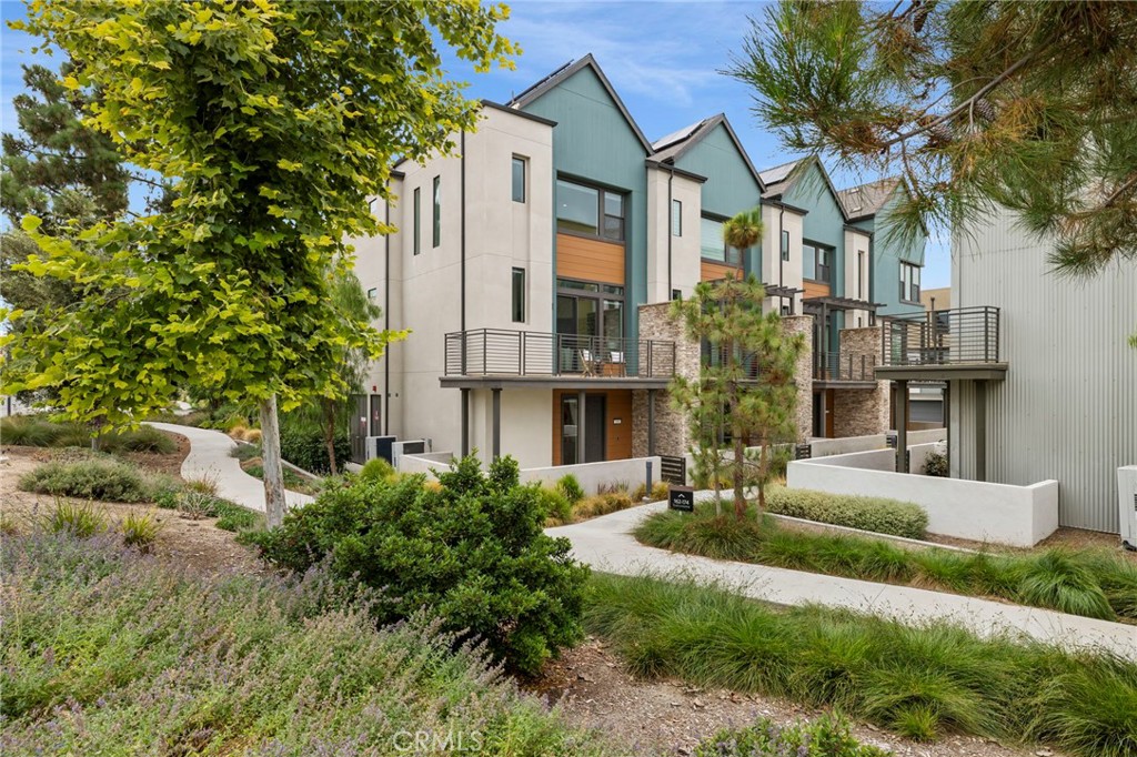 Discover this beautifully upgraded 2-bedroom, 2.5-bathroom home nestled in the sought-after neighborhood of the Great Park community. Built in 2020, this end-unit townhome offers 1,631 sq ft of thoughtfully designed living space. Step inside to find upgraded flooring throughout the first and second levels, an open-concept kitchen with a sleek backsplash, stainless steel appliances, recessed lighting and a bright, airy layout that flows seamlessly into the dining and living areas. The third floor features two spacious bedrooms, including a primary suite with a barn door leading to the private bath with dual sinks and walk-in closet. Additional guest room is spacious and includes its own private bathroom and a walk-in closet. Additional features include solar panels, an attached 2-car garage with an EV charging station, HVAC system, tankless water heater, spacious balcony off the living room and abundant natural light. Laundry is located on the 3rd floor near the bedrooms for convenience. Enjoy the vibrant community with access to top-rated Irvine schools, parks, pools, shopping, and dining—all just steps from your door. This move-in-ready home is the perfect blend of style, comfort, and convenience.