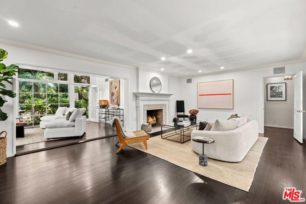 Tucked away in the prestigious enclave of lower Bel Air, this classic residence radiates old-world charm and understated sophistication. Sun-drenched interiors and graceful traditional details create a peaceful escape from the city's pace-offering the ideal turnkey retreat or a stunning canvas for your dream transformation. The home features four spacious bedrooms and a dramatic family room with exposed beams and soaring floor-to-ceiling windows. Rich wood floors flow throughout, enhancing the warm and inviting atmosphere. Outside, the lush, secluded grounds are a true sanctuary-complete with a serene rock waterfall, fire pit, and majestic trees anchoring the landscape. They simply don't build homes like this anymore-this is the Bel Air that defined glamour and gave the neighborhood its iconic status. Don't miss your chance to own a piece of Hollywood history and live like the legends.