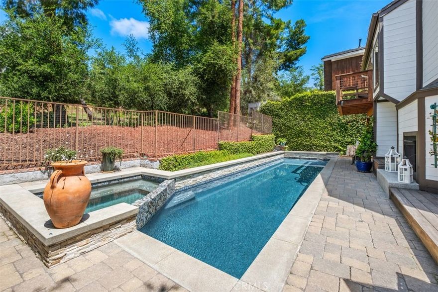 Step inside this very unique and remodeled pool home in The Village community in Coto de Caza.  This 3 Bedroom, 3 Bath home encompasses approximately 2,185 square feet and features modern and sleek amenities that make it very special.  The kitchen is a cook's delight with Viking appliances and a Subzero refrigerator.  The concrete peninsula floats between the kitchen and the dining room and contains abundant storage and a working counter for cooking or a buffet island for serving.  There are high ceilings and beautiful windows to bring natural light in from the outside and views of the soaring pine trees.  Downstairs you have 2 very large guest bedrooms, one with the bathroom en suite which could be a 2nd Primary.  The additional bathroom downstairs is a full bath outfitted with a large zero clearance walk in shower.  Upstairs is entirely dedicated to the Primary Suite and Bath.   The Primary Bath is very spa like and has a large soaking tub and a beautiful glass enclosed shower area.  There is an additional space for a vanity area or additional closet space.  The rear of the home features your own private pool and spa with complete privacy as there is nobody behind the home and a large open space.  The home has been customized throughout and is a delight to see.  There is also an additional loft space above the garage area which can serve as a private retreat or office area.  The house has many custom features that must be seen to be appreciated.  Whole house Life Source water filtration as well.  Located in the coveted Village community of Coto de Caza, enjoy access to world-class amenities Coto de Caza Golf and Racquet Club (optional memberships available), equestrian facilities, hiking trails, and more.