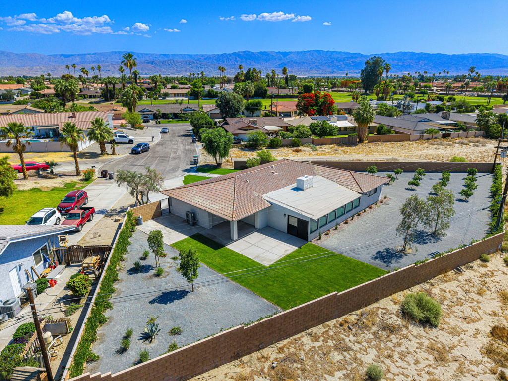 Amazing LA QUINTA MID-CENTURY GEM! Discover a one-of-a-kind opportunity in La Quinta with this beautifully updated mid-century home, perfectly blending classic design with modern style. Originally built in 1965, this home features iconic architectural elements of the era, now enhanced with contemporary finishes throughout--making it completely move-in ready.Situated at the end of a quiet cul-de-sac with no rear neighbors, this oversized, diamond-shaped lot offers unmatched privacy and stunning south-facing views of the Santa Rosa Mountains. The expansive, wrap-around yard creates a peaceful retreat with space to relax, entertain, or simply take in the scenery adjacent you your own citrus orchard.From the curb to the back wall, this home has been thoughtfully upgraded and renovated. A beautifully landscaped front approach leads to stylish new double doors, welcoming you into a bright and open interior filled with natural light. Large picture windows throughout frame the surrounding views and bring the outdoors in.Inside, you'll find brand-new flooring, renovated bathrooms, and a stunning chef's kitchen featuring custom cabinetry, quartz countertops, designer tile, and all-new stainless steel appliances. The kitchen's open layout and abundance of windows make it a true centerpiece of the home.The spacious bonus room on the rear of the home includes a built-in service bar that offers flexibility for a family room, game room, gym, or entertaining space--whatever suits your lifestyle.This property is a rare combination: timeless mid-century charm, modern upgrades, and a premium lot with privacy, breathtaking views, and pleanty of space to do so much more! Don't miss the virtual tour and schedule your private showing today--homes like this are rare, and once discovered, are cherished for a lifetime!