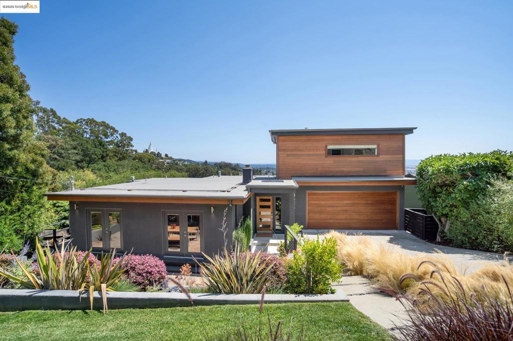 Designer-remodeled, mid-century modern dream house, with expansive views sweeping across the bay. The perfectly landscaped, low-maintenance front yard greets you as you pull up, complimenting the exposed warm wood of the home's facade. The spacious entry expands into open-concept living, dining and kitchen, thoughtfully and intentionally designed by the beloved local Banner Day Interiors; kitchen is custom walnut cabinets, backsplash is the lovely Tess Tile, and the hand-limewashed fireplace brings a natural, organic touch to the otherwise pristine space. With effortless flow from here to the front garden patio, or newly rebuilt back deck with bay views, this home seamlessly blends indoor/outdoor living. On this level is a full bathroom, bedroom (used by sellers as an office), interior access to the two car garage, and the world's most fun (yes, fun) laundry room and workout nook. Upstairs is one of two 'primary' bedrooms – with nearly 360 views and an en-suite bathroom. Downstairs, find the second 'primary' – your pick! – with a walk-in closet, en-suite bathroom with double vanity, and private deck. On this floor, too, is the fourth bedroom, also with an en-suite bathroom, & access to backyard. This stunner needs nearly nothing, but you. Time to come home.