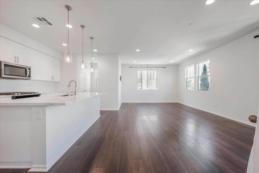Nestled in the heart of Oceanside, this stunning, newly built (3-year-old) townhome offers a blend of elegance and modern convenience. As you reach the main floor, rich, dark hardwood floors guide you into a spacious living room filled with natural light from the abundance of windows fitted with electric blinds. The kitchen features an expansive island illuminated by sophisticated pendant lights. Crisp white subway tiles complement shaker-style cabinetry, while stainless steel appliances promise both style and functionality. A walk-in pantry, and water softener system adds even more convenience. Upstairs, the primary bedroom provides a tranquil retreat, fully carpeted and cooled by a ceiling fan. A walk-in closet offers ample storage, and the ensuite bath indulges with a double sink vanity, a luxurious soaking tub, and a glass-enclosed shower. Two secondary bedrooms here allow you to enjoy direct access to a full bath. Meanwhile, the lower level houses one bedroom with easy access to a full bath as well as a private deck for soaking up the sun or stargazing under the night sky. This townhome offers a prime location. Community amenities including a jacuzzi, pool, BBQ, and 3 playgrounds ensure plenty of activities regardless of the season. Pet Friendly Pet Deposit - $500