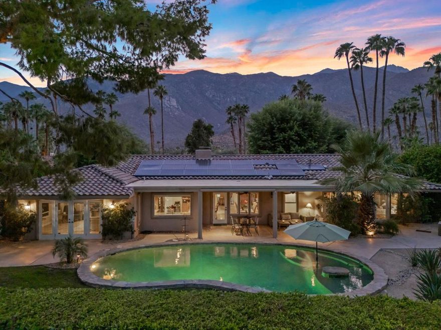Surrounded by soaring mountains, perfectly poised beside Frank Sinatra's favorite Palm Springs golf course and Walt Disney's personal retreat, lies a Mediterranean Modern gem that blends enduring elegance with modern functionality, natural charm and indoor-outdoor living in the heart of the exclusive Indian Canyons neighborhood. After passing through the stunning custom-crafted entry gate, you're embraced by an alluring private front courtyard, ideal for sunset cocktails and nighttime star gazing among bountiful bougainvillea, oleander and mesquite trees. Once inside the rustic pecan door, you're welcomed by a light-filled foyer with tumbled travertine tile seamlessly connecting a comfortable living room with large gas fireplace to pool view dining and entertainment spaces including a sumptuous eat-in kitchen with sparkling granite countertops, tailor-made cabinetry and a gourmet indoor barbeque. Beyond are two spacious patios, a heated pebble tech pool with tanning ledge, and a bubbling jacuzzi, beckoning you to stretch out and relax in this wonderous backyard sanctuary. The home's north wing leads to a relaxing master suite and bath with rainfall shower and clawfoot tub adjoining a secluded fountained alcove.  A lovely second bedroom graces this section of the home, as does a third bedroom or den with artisan-designed built-in shelves and drawers. Across the hall is a spa-inspired bathroom with oversized shower alongside handcrafted cabinetry and vanity table. On the south wing is a well-appointed home theater, complete with recessed Aquos Quattron 80'' 3D TV and Denon multi-media sound system. Tucked nearby is a cheerful home office plus a full-size laundry room and two-car garage. Overhead, a 32-panel solar system provides performance guaranteed year-round comfort and smart technology at a significantly below market lease rate. When you wish upon a star for the ideal primary or second residence, or luxury vacation rental property for celebrity guests, this 2569 square feet of desert heaven is everything you could ask for and much more.