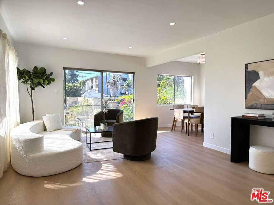 Spacious and updated Mid-Century condo in the heart of Los Feliz! This is a truly unique offering - a top-floor, end-unit condo in a quiet 1950's building, which has been completely restored and updated top-to-bottom with all new systems and designer finishes. The Ambrose sits on a peaceful street, lined with mature palm trees, perfectly situated within a desirable pocket of Los Feliz - between Hillhurst and Vermont. Tucked away to create calm, privacy and a connection with nature, yet close to all of the amazing amenities that make this neighborhood special! Originally built in 1959, the complex has been lovingly kept by the close-knit association, and retains that sought-after Mid-Century charm. Within this intimate complex, #8 stands out as an extraordinary unit. Sited on the top level and at the back with only one shared wall, the condo feels both airy and private, perched up away from the street. A complete retrofit and redesign has just been completed, with virtually no surface left untouched. Systems such as plumbing, electrical and drain lines have been replaced. Walls have been stripped to the studs and reinforced, with new high-rated insulation added. New flooring, drywall, paint and recessed lighting throughout give a comfortable and luxurious feel. A brand new, oversized kitchen is chef-ready with all new cabinetry, quartz counters, stainless appliances, custom lighting and ample storage. The kitchen opens to a dedicated dining room with huge windows and a sleek chandelier. The spacious living room has a flexible layout, space for a WFH setup, and sliding glass doors that open onto the private balcony. The center hall boasts ample storage, including space for an in-unit W/D combo. Off the hall, a full bath perfectly incorporates an original cast iron tub with new designer tile, vanity, lighting and fixtures. The large primary bedroom creates a perfect retreat with clerestory windows, walk-in closet, and a beautiful new en-suite bath with walk-in shower, frameless glass enclosure, and dramatic floor-to ceiling tile. Meanwhile, the second bedroom is perfect as a guest room, office or nursery, and also includes an oversized walk-in closet. Located mid-block on Ambrose Ave, the building's location gives an ideal blend of privacy and convenience. Close to Griffith Park, transit, freeways, as well as the countless cafes, shops and dining options in Los Feliz and the surrounding neighborhoods, the home is also convenient to studios and employment centers in nearby Hollywood. With a sensible floor plan, original charm, meticulous upgrades, and thoughtful finishes, this move-in ready condo strikes a perfect balance and sits ready for its next chapter!