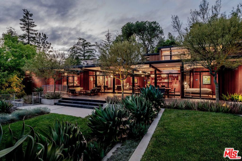 Mid-Century Modern Masterpiece located on a quiet cul-de-sac in the beautiful foothills of La Canada Flintridge. This architectural marvel was custom built in 2008 and awarded a prestigious Architectural Merit Award by the Pasadena Foothill AIA. Exceptional design with the utmost attention to detail is showcased through walls of concrete, stone, redwood and glass with black steel accents and custom lighting throughout. Situated on over a 1/2 acre lot, this home features 5 bedrooms, 5 baths, a bright open floor plan and sleek minimalist aesthetic. Floor-to-ceiling windows with massive Fleetwood sliding doors open to spectacular private patios, lawns, decks and meticulous landscaping, seamlessly blending indoor and outdoor living flawlessly. There's a custom Bulthaup kitchen with top of the line Gaggenau appliances. Family/Media Room with TV, recessed movie screen, projector and surround sound. A private seating area features a stunning cantilevered staircase and stone fireplace. Outdoors is an amazing entertainment space with kitchen, pool, jacuzzi, sauna and steam shower. Complete Crestron home automation system includes all lights, climate, A/V, automated recessed blinds, security and cameras. Other features include fully-owned solar panels, new Ruberoid roofing system, dual primary suites, expansive temp controlled wine cellar, custom redwood interior built-ins, central vac system, 3 fireplaces, full laundry/utility room. Exterior workshop area with 2 bonus rooms perfect as a home office, gym or potential guest space. The long private driveway leads to a carport with oversized garage and storage room. Soon to be included in the award winning La Canada School District. This home is turnkey and truly one of a kind.