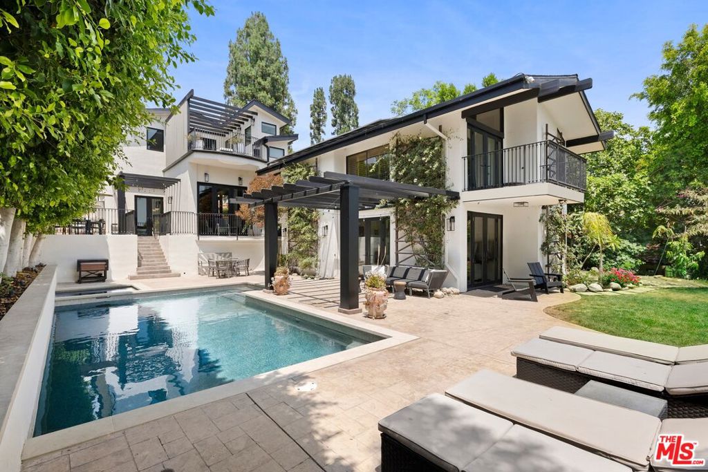 Presenting this gated and remodeled entertainer's compound complete with tennis court, adjacent sports field, and fantastic views of the Valley and mountains beyond. Secured and set behind privacy hedges, the home offers an abundance of parking in its large motor court with porte-cochere and three-car garage. The living room has a sophisticated marble fireplace, exposed beams, vaulted ceilings, loft, and an open flow to the dining room. Nearby, the kitchen has been upgraded with beautiful finishes, fixtures, and top-of-the-line appliances, and the family room is complete with a bar area and multiple sets of French doors to the outside. The primary bedroom has an additional fireplace and opens to a large balcony with a stunning view, and its en-suite bathroom is updated and appointed with an oversized shower and soaking tub. Some secondary bedrooms also have their own private balconies, including the guest quarters. For exercise, yoga, and meditation, there is also a gym. Outside, enjoy multiple terraces, trellis-covered patios, outdoor barbecue, and viewing areas as well as a sparkling pool and spa, all surrounded by manicured landscaping. Enjoy this central location close to Gelson's, the Balboa Golf Course, the shops and restaurants along Ventura Boulevard, and the 101 and 405 Freeways. The home is also located within the attendance boundaries of top-rated Lanai Road Elementary School. Tennis court and sports field are shared with adjacent neighbors.