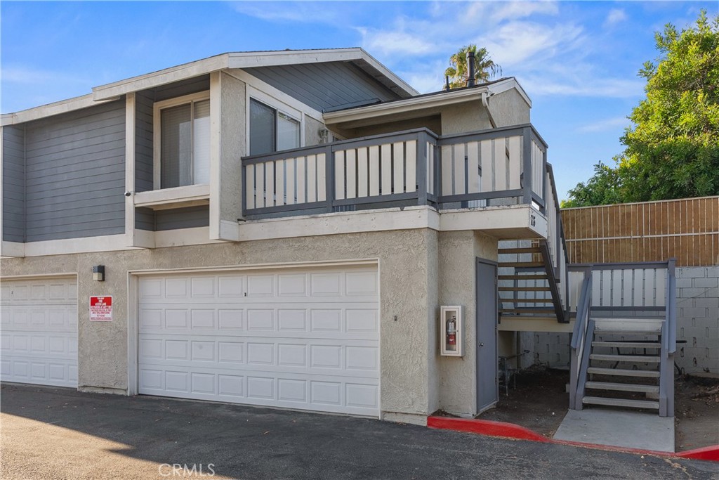 Detached carriage-style condominium with no shared walls, featuring the privacy of a single-family residence. This home features an attached two-car garage directly below the unit. The interior includes an open living and dining area with updated vinyl plank, laminate and tile flooring, a remodeled kitchen with quartz counters and stainless steel appliances, and spacious bedrooms. Additional highlights include a private balcony, updated bathrooms, and in-unit laundry. Located in a small community with easy access to freeways, shopping, and schools.