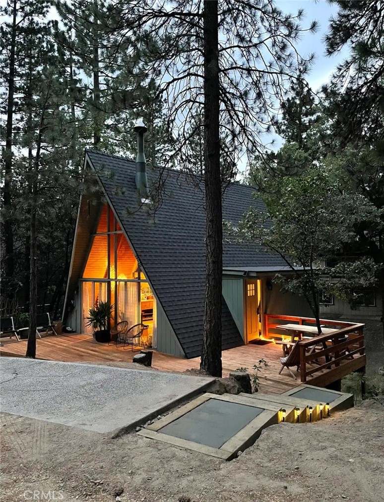 Escape to this beautifully updated A-frame cabin, where rustic charm meets modern comfort for a perfect year-round retreat. Step inside to be greeted by soaring vaulted ceilings and an open, airy living space designed for relaxation. Up the original floating staircase, the spacious loft offers a peaceful master hideaway and a charming mezzanine desk nook—ideal for work-from-home or creative inspiration. With thoughtful touches like AC, heating, and a ceiling fan, comfort is guaranteed in every season. The heart of the home is the rustic yet fully equipped kitchen, perfect for preparing delicious meals while staying connected to the warm and inviting dining and living areas. A striking Hase Bari fireplace (ultra clean catalyst combustion wood stove) serves as the centerpiece, creating the ultimate cozy ambiance. Down the hall, a charming guest bedroom and a beautifully finished bathroom with Cle cement floor tile, provides a welcoming space for family and friends. Outside, a spacious shaded deck invites you to unwind with your morning coffee or stargaze on crisp mountain evenings, surrounded by the peaceful beauty of nature. The level parking pad offers convenience, complete with an EV charger for added ease. There is room to expand this modern, all-electric mountain retreat that offers both privacy and relaxation with an open treed lot and seasonal creek.
Whether you're searching for a full-time mountain escape, a weekend getaway, or a turnkey short-term rental, this enchanting cabin is ready to welcome you home.