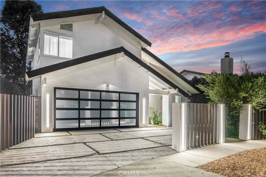 This stunning 4-bedroom, 3.5-bathroom two-story home has been completely reimagined, offering modern luxury at the end of a peaceful cul-de-sac in Encino. From the moment you arrive, double doors welcome you into soaring two-story ceilings, an elegant staircase, and a spacious, light-filled open-concept formal living area. The space flows seamlessly into the formal dining room, complete with a cozy fireplace and a sleek, double-sided wet bar—perfect for entertaining. The oversized gourmet kitchen is a chef’s dream, combining striking form and practical function. It boasts clean lines, dramatic quartz countertops and backsplash, abundant counter and storage space, and a oversized center island. The kitchen flows effortlessly into an informal living space. Downstairs, a versatile bonus room provides flexibility for use as a private office, guest room, gym, media room, playroom, studio, or third living area. From the kitchen, step outside to a private backyard oasis with a grassy lawn and a covered patio—perfect for grilling, entertaining, or enjoying weekends with friends and family. Upstairs, the spacious primary suite boasts vaulted ceilings and two generous closets, including a walk-in. The luxurious en-suite bathroom is appointed with dual vanities and a walk-in waterfall shower. Three additional bedrooms and 2 fully updated bathrooms are also located on the upper level. Two of the bedrooms open onto a sprawling 366-square-foot private balcony—an ideal retreat for morning coffee or quiet evenings. The larger of the 2 balcony-access bedrooms features an extra-large custom-built closet for added storage. Located just minutes from schools, Lake Balboa Golf Course and Recreation Area, the Sepulveda Basin bike path, a popular dog park, Trader Joe’s, and numerous shopping and dining options. Enjoy easy access to Ventura Blvd, the Orange Line, and the 101 and 405 Freeways.