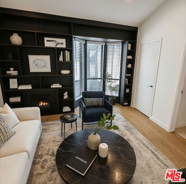 A rare gem in West Hollywood's coveted Norma Triangle, this sleek 2-bedroom, 2.5-bathroom townhome offers the perfect balance of modern design and serene living.The townhouse has been fully updated. A custom bar/wine bar was installed, adding a touch of sophistication and style for entertaining. Every detail has been thoughtfully considered to create a welcoming space that feels both chic and comfortable.Inside, you'll find an expansive open-concept living and dining area centered around a cozy gas fireplace. The recently renovated gourmet kitchen shines with stainless steel appliances and a stylish breakfast bar. Upstairs, both bedrooms feature ensuite bathrooms, with the primary suite offering its own fireplace and a true sense of retreat.Additional highlights include in-unit laundry, central AC/heat, LED recessed lighting throughout, and community perks like a heated pool and two tandem underground parking spaces. Best of all, the location can't be beatjust moments from the San Vicente Bungalows, Petit Ermitage, Pavilions, and West Hollywood Park.This is a rare opportunity to own a fully updated, stylish townhome in one of West Hollywood's most desirable neighborhoods. Can come partially furnished: Flat panel TV; Dining table & chairs; patio bistro table & chairs; brand new King bed frame/mattress. Disclaimer: Virtual/AI staging in some listing photos.