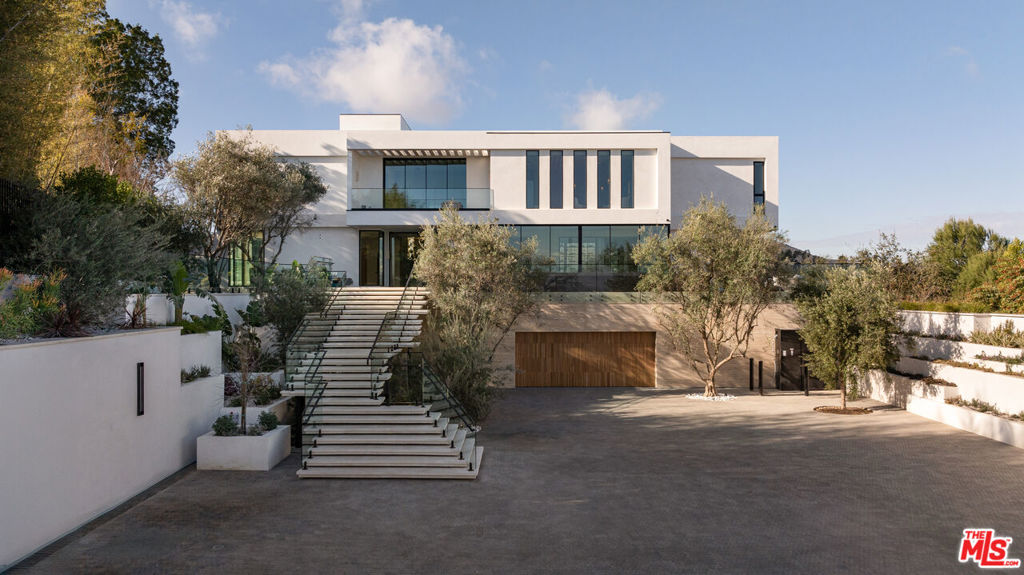 Discover 16187 Royal Oak Rd, a bold fusion of luxury, design, and unparalleled views in Encino's most sought-after enclave. This contemporary estate, set on nearly two acres, delivers a lifestyle of sophistication and tranquility. From the moment you step through the grand pivot door, you're greeted by open spaces, dramatic ceilings, and panoramic city and canyon vistas through walls of glass. The heart of the home is a chef's kitchen that seamlessly flows into living and dining areas, designed for effortless entertaining. Step outside to your private oasis, complete with an infinity pool, spa, and ample lounging space all framed by lush, secluded landscaping. With 8 bedroom suites, 11 baths, a state-of-the-art home theater, wine cellar, gym, and spa, every inch of this home is crafted for comfort and style. The primary suite is its own retreat, featuring a private terrace, and a spa-like bath. Come and experience an estate where exceptional design and serene beauty meet, creating a living experience like no other.