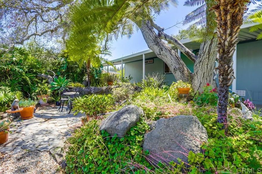 Up to 5% Down Payment Assistance available!  This spacious & bright 3 BR plus office or 4th BR home has everything you’ve been looking for, and you OWN THE LAND – no space rent & no age restrictions!  Vaulted ceilings, skylights, dual pane windows, woodgrain plank flooring, large kitchen with island & space for both breakfast & dining tables.  Primary bedroom has 2 closets, ensuite bath with dual sinks & dual shower heads, plus an adjacent office or nursery.  2 additional bedrooms at other end of the home.  Peaceful views out every window.  New roof in 2024!  Incredible yard with slate patio areas on each side of the house.  Any time of day there is a shady spot to relax under the canopy of trees & enjoy the cool breezes, chirping birds, green plants, & giant boulders.  Corner lot with lovely curb appeal, close to guest parking.  Home is on a permanent foundation with 433A recorded.  Conventional, FHA & VA financing available.  2 pets allowed & there are beautiful trails to walk with them in the community.  Very low $180 monthly HOA fee includes trash & sewer.  Amenities include clubhouse with kitchen & game tables, pool & spa heated year-round, playground, RV parking, tennis & basketball court.   The Del Lago Academy of Science, Technology, Engineering & Mathematics is within walking distance.  Close to shopping, restaurants, hiking & biking at Lake Hodges.  Come see your new home today!