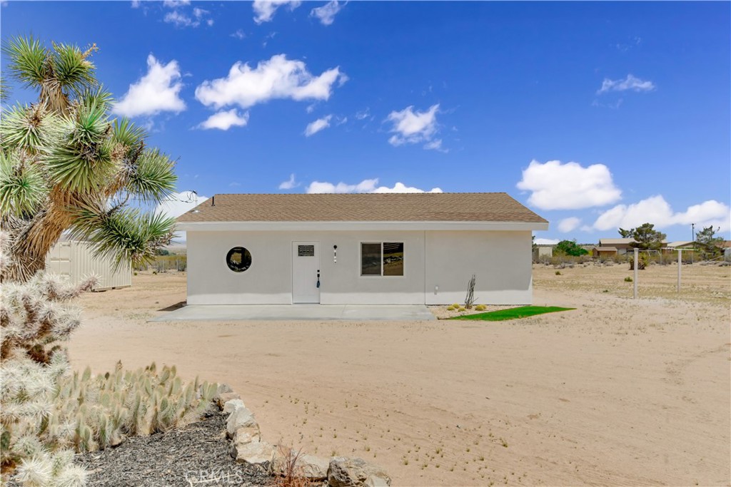 Cozy home in the desert of Landers! Built in 1960, with 1049 square foot of living space, this two bedroom plus den, one bath home sits on a expansive 5 acre lot offering the perfect blend of functionality and natural desert beauty. Approximately half an acre has been cleared and securely fenced, the rest of the property remains in its natural desert state, preserving the area's rugged beauty. Upon entering, you will be greeted by a spacious open floor plan featuring a light paint scheme, finished concrete flooring flowing throughout the home, recess lighting, windows, and abundant natural light. The generous living room seamlessly flows into the kitchen, which showcases a fun, decorative paint scheme. The stylish design features a grey tile backsplash beautifully contrasted by olive green cabinets and light-colored countertops. Completing the space are modern appliances, including an electric stove and oven with a hidden range hood and dishwasher, while recessed lighting and a fun light fixture enhances the bright and inviting atmosphere. Down the hallway, you will find the bedrooms, den and bathroom. The bathroom features a walk in shower, single sink vanity, with finished concrete flooring. The two bedrooms features finished concrete flooring, high ceilings, and an abundance of natural light streaming through multiple windows. One of the rooms is conveniently attached to a spacious den area, offering a versatile space that can be used for work, an office or extra storage. Outside, the expansive property beckons with endless possibilities, showcasing low-maintenance desert landscaping, a back patio area to enjoy, and RV parking. This property also includes a Conex box for extra storage while the blank canvas awaits your personal touches and creative vision. Conveniently located 2 miles from Highway 247, this home offers easy access to shopping, dining, and public transportation while still providing a sense of privacy.