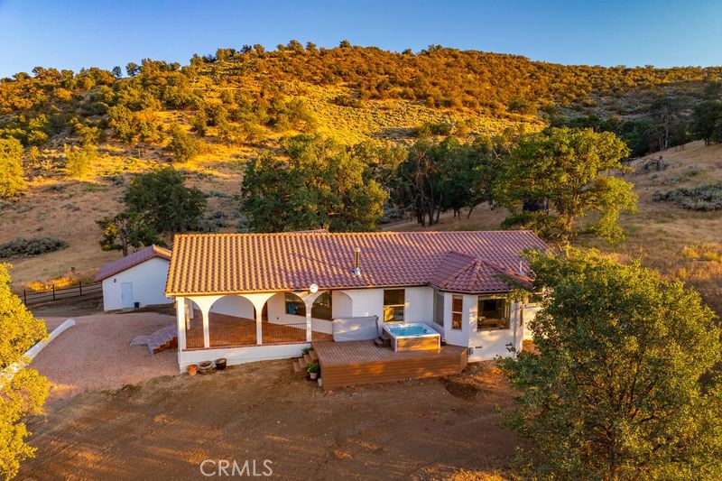 Welcome to 23001 Yodel Drive, a Spanish-inspired home set in the rolling hills of Tehachapi. This property has received extensive recent upgrades, blending classic design with modern updates.
Enter through the Spanish-style arched entry and Saltillo-tiled porch, where hillside views set the backdrop. Inside, the home features a new kitchen, updated bathrooms, new white oak engineered wood flooring, fresh paint, and high-end finishes throughout.
The outdoor deck connects to the covered porch and leads to a private spa, creating an inviting space to relax or entertain while taking in the surrounding scenery.
Currently operating as a successful short-term rental, this property is offered fully furnished, providing a turn-key opportunity for investors, second-home buyers, or those seeking a primary residence in a serene setting.
Located close to town yet surrounded by natural beauty, 23001 Yodel Dr offers both convenience and retreat.