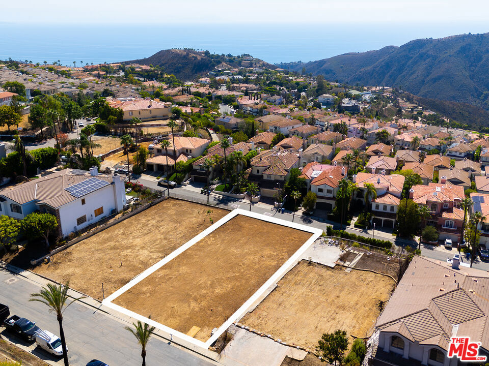Perched high in Pacific Palisades' Summit Enclave, this panoramic ocean and mountain view lot within this highly coveted, guard-gated community offers a rare opportunity to own, design, and build a custom estate that captures the essence of the Southern California lifestyle. From its elevated vantage point, the property showcases sweeping, unobstructed views of the Pacific Ocean and surrounding mountains, creating an inspiring backdrop for a new architectural vision. The oversized lot, formerly home to a 5,700-square-foot residence with pool/spa, is now fully cleared and ready for immediate development, with both the EPA Phase I environmental assessment and Phase II debris removal complete. Residents of "The Summit" enjoy an exclusive resort-style lifestyle with exceptional amenities including tennis courts, an Olympic-sized swimming pool, spa, fitness center, playground, with basketball and pickleball courts, all just moments from the Palisades Village.