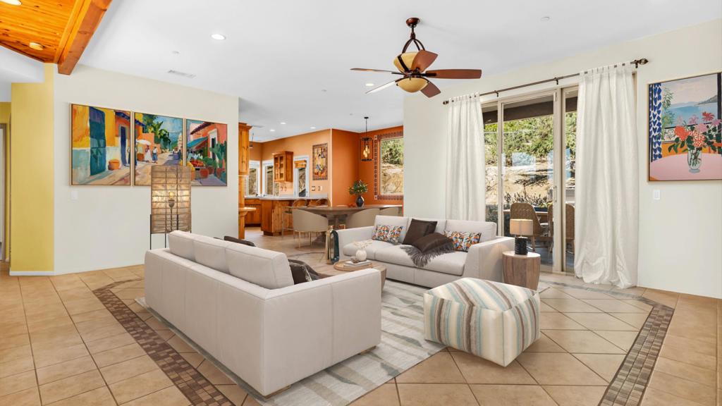 Experience elevated Yucca Valley living in this Sante Fe style home with panoramic mountain and desert vistas from every window, and two outdoor patios for indoor outdoor living. This 3 bed, 2 bath home exudes the distinctive flair of the southwest with wood beam ceilings, gorgeous unique woodcrafted cabinetry, Talavera tiles as backsplash, light plates, window accent, artwork, and cabinet knobs. Open concept living room and dining area are centered with a striking fireplace, and stunning views that captivate your eyes. The kitchen is spacious and ready for the busy cook with SS appliances, trendy black sink and faucet, under cabinet lighting, and a door to the back patio for easy outdoor BBQ and dining. There is a breakfast bar to seat 3 comfortably, a workspace, and glass front cabinets. The primary bedrm is set apart for privacy, slider to the back patio, large walk-in closet, large ensuite bath, separate shower, double sinks. Two guest bedrms are roomy, carpeted, and one has a walk-in closet, share the nearby convenient guest bath. The front courtyard beckons you at night to take in the city lights below from your hillside perch. The back courtyard is covered and roomy perfect for dining out or taking quiet moments from a lounge chair. Close to shopping, dining, and attractions like Joshua Tree National Park. Retirees downsizing will find comfort in the single-story design and SW charm. Creative professionals, entrepreneurs, locals will enjoy the inspiring views and space to create--indoors and out. Remote workers can escape the city and work from a serene, stylish environment. Second-home buyers will find an easy lock-and-leave home less than two hours from Los Angeles. Original architectural details offer a classic desert aesthetic, while the spacious lot invites endless possibilities--whether it's a garden, workshop, studio, or outdoor lounge. Soak in the serenity with morning coffee on the patio or wind down as the sun sets over the hills. This is the home you've been searching for.