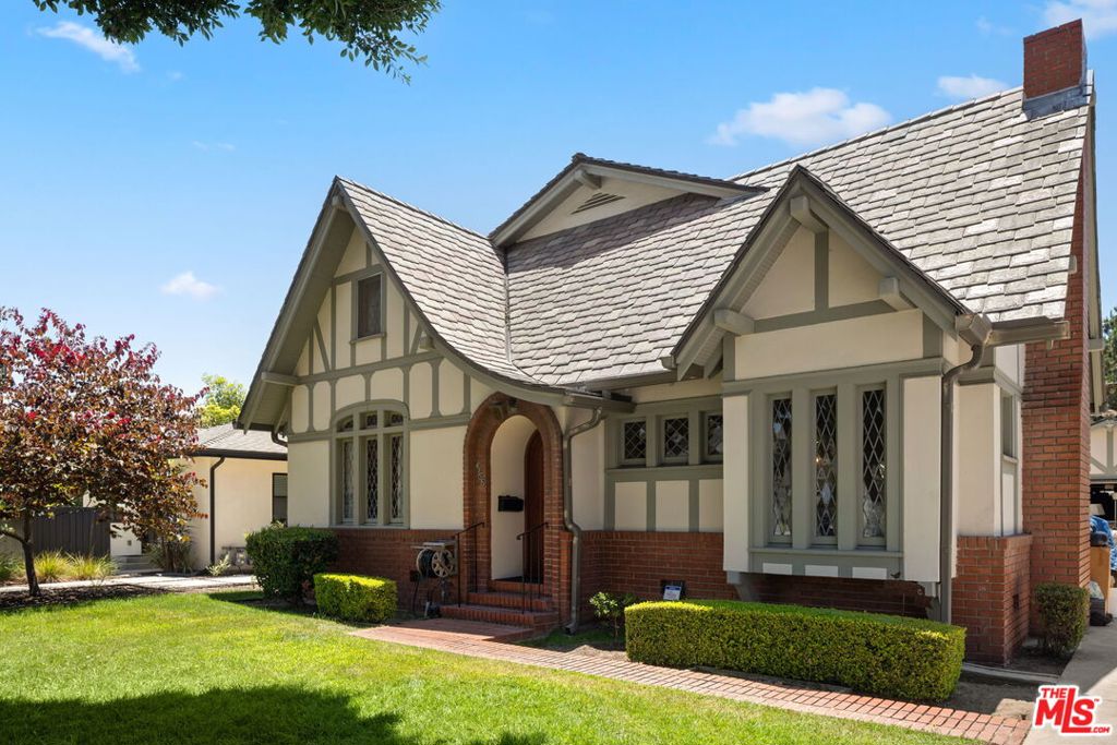 Classic 1924 Tudor on Prime Tree-Lined Street Near Downtown Culver City. This timeless Tudor-style residence offers over 2,600 sq ft of living space on a generous 6,750 sq ft lot. Ideally located just blocks from vibrant downtown Culver City, this home exudes original charm preserved by longtime owners. Step into a spacious living room with leaded glass windows, a cozy fireplace, and a sunny window seat. Gorgeous hardwood floors flow throughout the home, leading to a large wood-paneled den...ideal as an office or music studio. The expansive formal dining room features French doors that open to the yard and driveway, perfect for indoor-outdoor entertaining. A bright kitchen includes a built-in desk, drawer nook, and charming breakfast booth. The adjacent service porch houses the laundry area and provides access to a full-size basement...great for a game room, pool table, or creative retreat. With four generously sized bedrooms and three bathrooms, the home also boasts abundant closet space, additional storage, and even a hidden bonus room. The backyard is an entertainer's dream, with a covered patio, built-in brick BBQ, and a must-see basketball court.