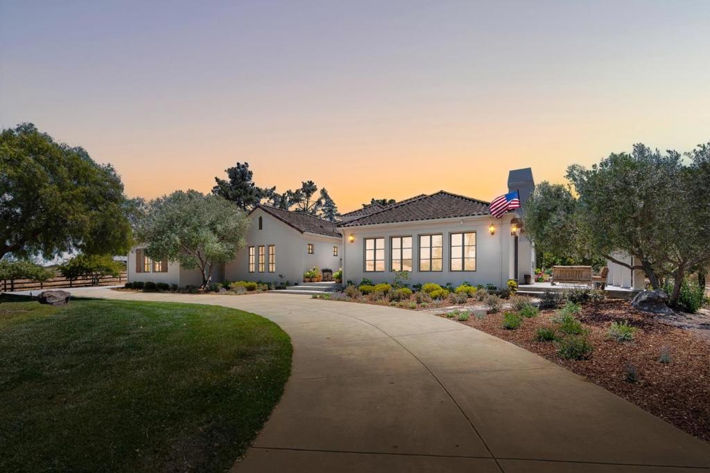 This secluded Mediterranean estate offers views of the Salinas Valley below and more than 5,600 sf of elegant, open living space. You can spread out indoors or enjoy the four flat, usable acres outside. The open kitchen flows into the large living room and dining area, with French doors leading to patios on three sides of the home. Each bedroom includes its own ensuite bathroom, and the large office provides privacy and natural light, opening directly onto an outdoor patio. Entertain in the main living area by the stone fireplace, or head to the family room featuring a full wet bar. For those cool summer evenings, gather on the outdoor patio beside the fireplace, while the kids climb the sprawling oak tree below. Your in-laws will appreciate the independence of the separate one-bedroom guest house with a full kitchen, living room, laundry, and its own one-car garage. The flat four-acre parcel offers space to roam, relax, or even ride - complete with a two-stall horse barn, garden beds, chicken coop, and ample water. Whether you're dreaming of homesteading or just want some breathing room, you've got options. Modern elegance, privacy, open space, and sweeping views - this property has it all, just minutes from Monterey, Carmel, and the Salinas Valley.