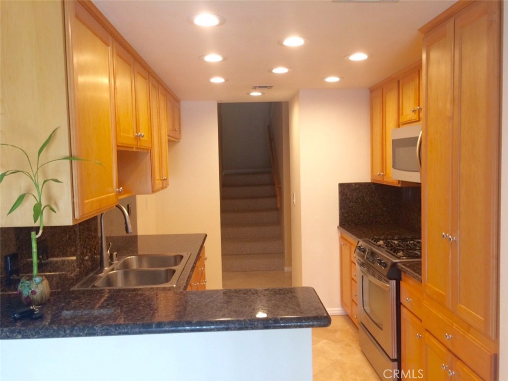 Spacious 3 BR townhome at “Warner Club Villas” in the heart of Warner Center. No renovations needed--just come in the door and feel right at home. Rare end unit only shares one wall, prime location in complex. New paint & carpet w/modern neural colors feels light & bright. Gorgeous granite kitchen & bathrm counters, custom cabinets, all stainless steel appliances, gas stove, dishwasher, sink, & micro. Cozy fireplaces in living rm & master. LED recessed lighting & smooth ceilings throughout. Alarm system wired. Enjoy outdoor gatherings & BBQs on the private garden patio. 100% ready for you to settle in & relax. Washer/dryer & garage frig included in the private 2 car garage w/direct access. Beautifully maintained complex, resort like pools/spas/tennis courts. HOA pays EQ ins/water/trash/24 hr roving security. Ideally situated near Warner Park, The Village/Westfield Mall, Costco, Trader Joes, Starbucks & more!! LA Rams billion $$ investment in Warner Center is sure to enhance the value & appeal of this already remarkable townhome. HOA rule-1 pet under 30 lbs.