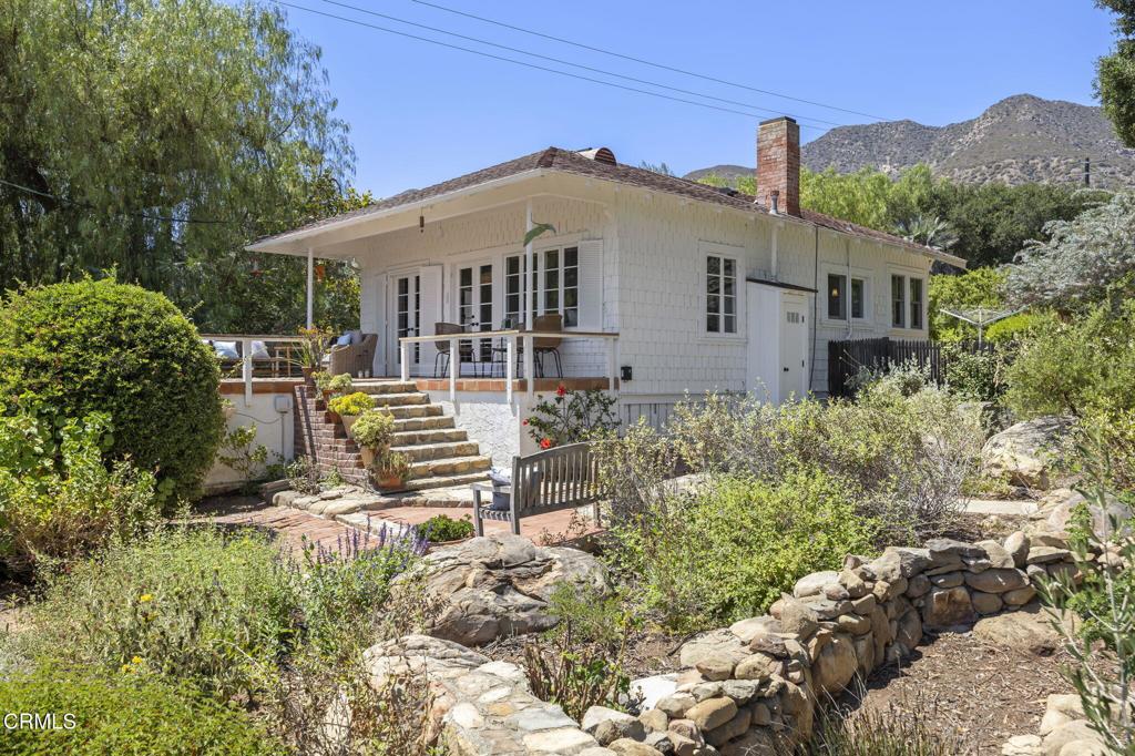 Tucked down a long and private wooded drive in Ojai's prestigious East End, bordered by hand-stacked stone walls, you will find this enchanting 1910 cottage on over 2.4 acres, with a generous pool and charming guest house. Built by the Gorham family, who owned the surrounding acreage and which they dubbed Whale Rock Ranch, this little piece of Ojai history is a treasure that has only been on the market once or twice before. The home has high ceilings, wood floors, built-in bookcases and enjoys lots of natural light. The sweet farmhouse kitchen is clean and functional and graced by a vintage wallpaper scene of 19th century Paris. The cozy bedrooms, with many windows and lots of closet space, are so relaxing, and the mud room with built-in laundry is neat and practical. The oversized garage provides plenty of storage and could be a yoga or art studio. Plumbing, electrical and septic have been upgraded. The current owner's husband, a landscape architect, planted a mix of California natives and drought tolerant plants from South Africa and Australia. He also added a walled and fenced vegetable garden (also good for chickens) and planted a small orchard with citrus and stone fruit. A mature olive grove and a massive boulder at the back of the property are the stuff of inspiration and imagination. If one is looking for the slow-living lifestyle, this magical property is ready to choose a new steward and, just maybe, it could be you.
