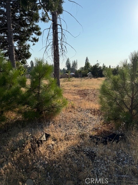 Beautiful large lot in a wonderful neighborhood setting that is being rebuilt all around this location. Property is close to shopping, dining and easy access down the hill to Paradise and Chico. Property is located in the Paradise Pines and has a wonderful swimming pool/ spa, tennis counts, pool table, air hockey and basketball courts. A few large healthy trees are still standing and the lot has two rose bushes that add life to the lot.