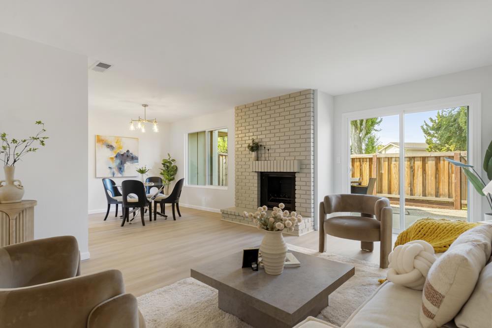 Set at the beginning of Burke Lane just steps from Central Lake, this Harborside townhome blends stylish updates with a desirable Foster City location. A cheerful red door welcomes you into a refreshed interior where luxury vinyl plank flooring flows throughout. The living/dining is anchored by a brick-clad wood-burning fireplace with a gas starter, framed by leafy views through glass sliders. Outdoors, the pebbled concrete patio offers space for multiple seating areas or al fresco dining, with a gate directly to the greenbelt. The dining space with a chandelier overhead connects seamlessly to a renovated kitchen with shaker cabinetry, quartz countertops, stainless steel appliances, and a large pantry cabinet, plus room for casual dining. Upstairs the primary suite enjoys a private balcony with peek-a-boo hillside views & an updated ensuite with a stall shower with wide format tile surround, & walk-in closet. Two secondary bedrooms share an updated hall bath with playful starburst tile. Downstairs an updated half bath, laundry room with LG machines, and two-car garage with painted flooring add convenience. Community amenities include a pool, tennis courts, and a beach for waterway access. Close to Farragut Park, Edgewater Place, Marlin Cove, and Beach Park Elementary.