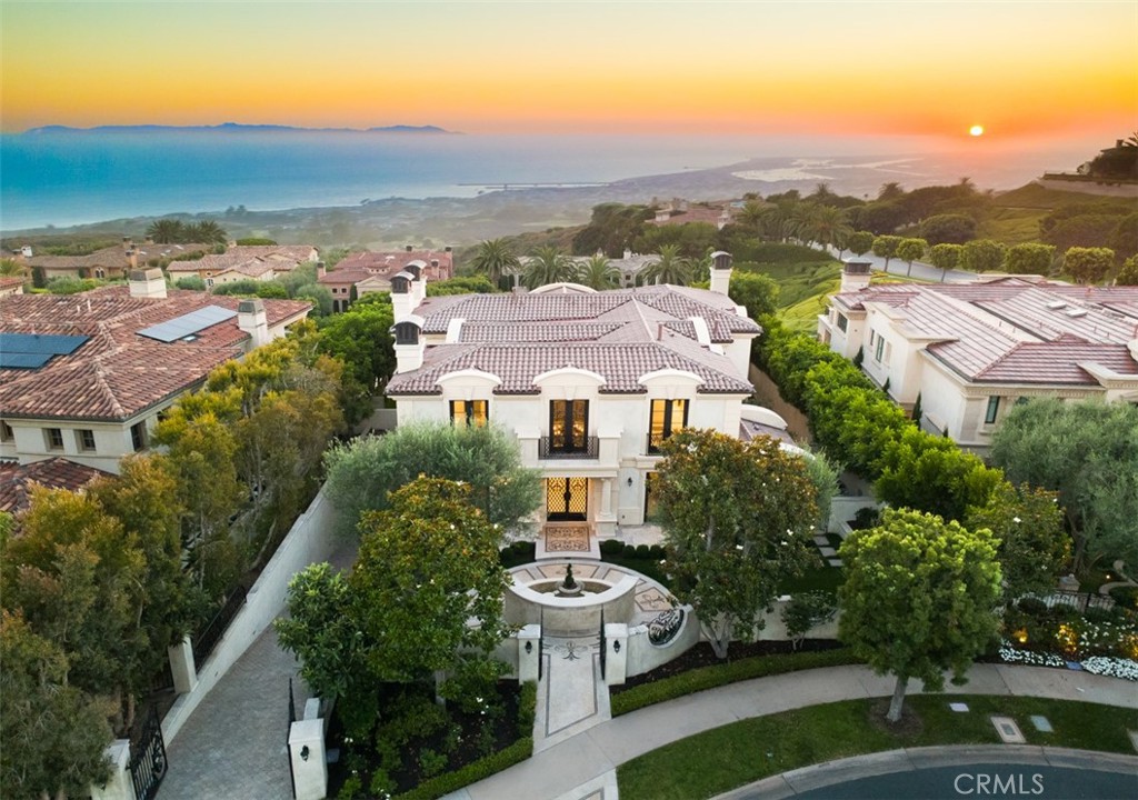 Exquisitely reimagined in 2025, this French palatial manor designed by acclaimed architect David Pierce Hohmann pairs timeless European elegance with fresh, modern sophistication. Set on a 13,155± sq. ft. parcel in the prestigious guard-gated enclave of Pelican Crest, the 8,367± sq. ft. residence commands sweeping views of the Pacific Ocean, Catalina Island, Newport Harbor, and the famed Pelican Hill Golf Course. Behind its stately façade, every detail has been elevated with the finest materials and craftsmanship: natural limestone and white oak herringbone floors, hand-brushed Venetian plaster, Moka Creme honed stone in all wet areas, and bespoke solid brass hardware in oil-rubbed bronze or polished nickel. The two-story foyer with antique chandelier leads to a grand staircase, gracious formal living and dining rooms with custom fireplaces, a richly appointed wood-paneled library, and a sun-filled family room with fireplace that adjoins the gourmet kitchen. A culinary showpiece, the kitchen featuring Calacatta Vagli marble surfaces, custom cabinetry, dual refrigerators, professional-grade appliance, and a built-in upholstered ocean-view banquette with custom breakfast table. The opulent primary suite offers a fireplace, spa-inspired bath with an ocean-view soaking tub, architectural glass-block accents for natural light, and a custom-designed closet. Additional amenities include five secondary suites, a tiered theater room, activity/fitness spaces, sauna, steam room, and a subterranean 7-car garage. Additional upgrades include a new roof, new HVAC system, all new plumbing connectors and two new water heaters. Outdoors, new stucco and roofing frame lush entertaining areas with a saltwater pool/spa and BBQ/kitchen with natural stone countertops — all set against a backdrop of endless coastal beauty. This is Newport Coast living at its most refined — where architectural artistry meets modern luxury in a rare, view-rich estate.