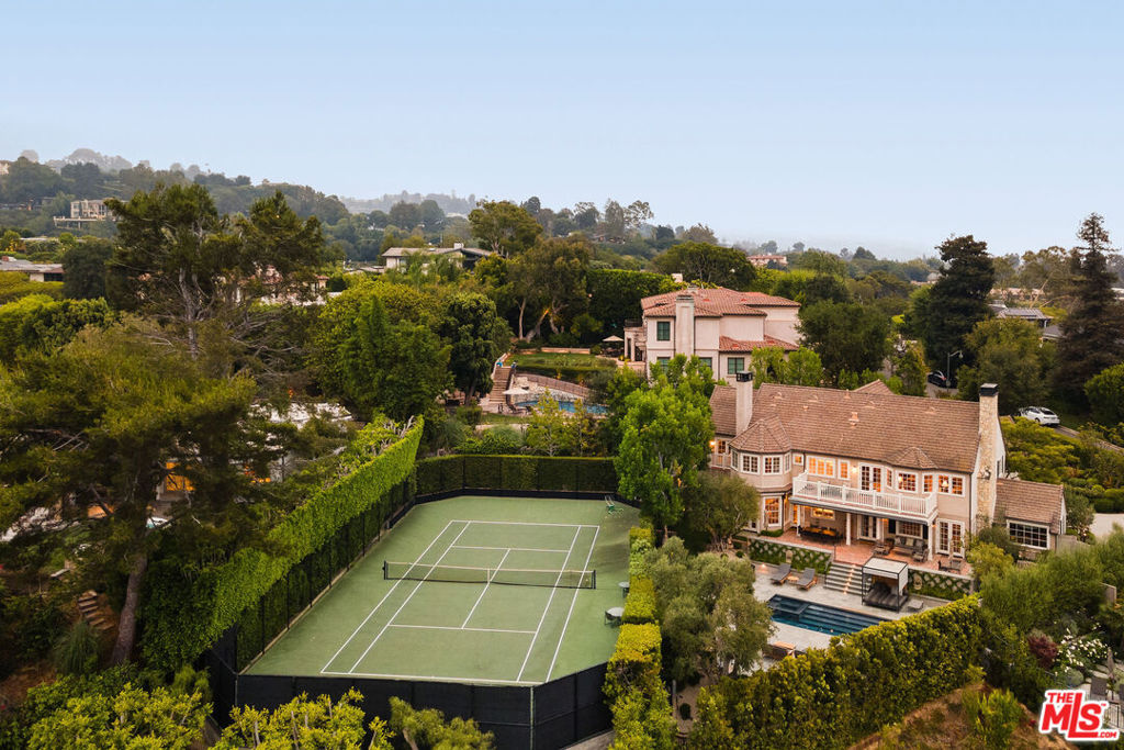 Elegant Bel Air Estate with Tennis Court, Pool & Timeless Charm! Set behind gates on a generous 25,969 SF lot, this timeless Gerard Colcord residence offers classic design, modern comforts, and exceptional amenities in one of Bel Air's most coveted enclaves. With approximately 5,616 SF of living space, the home features 6 bedrooms and 5.5 bathrooms, blending character-rich details, such as custom millwork, vaulted ceilings, and four fireplaces, with thoughtful updates including a new generator, central vacuum system, and integrated audio-visual wiring. The heart of the home is a chef's kitchen with Calacatta marble counters, top-of-the-line appliances, and a separate butler's pantry/scullery kitchen, perfect for entertaining with ease. The multiple living areas include a gracious formal living room with wood-beamed ceilings, a cozy den with wet bar, and a sunlit family room. Upstairs, the serene primary suite offers sweeping views, a fireplace, a spacious sitting area, balcony, huge closet, and a spa-like bath with a soaking tub and Calacatta marble shower. The incredible park-like grounds are designed for both recreation and relaxation. A full-size tennis court with basketball hoop, a pool and spa with Bluestone decking, and patio with retractable awnings create the ultimate indoor-outdoor lifestyle. Mature landscaping and privacy hedges frame the property, offering a tranquil retreat that's a short drive to Brentwood, Beverly Hills, Westwood, and more!