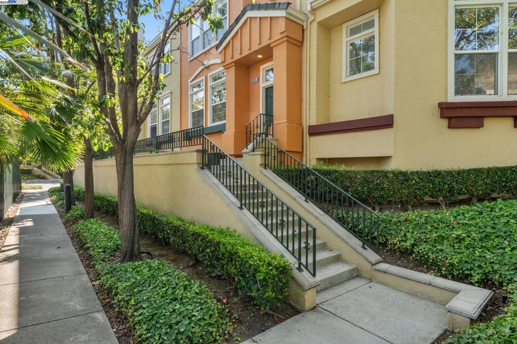 A popular floor plan townhouse located in one of the best locations within the desirable gated "Liberty Commons" community. Enjoy serene views of the community swimming pool from the balcony, living room, and primary suite. Bright living room with a cozy fireplace. Ceiling lights, window coverings, and sunblock shades in every bedroom. Dining area with ceiling fan/light and a custom wall-sized built-in bookshelf with desk. A well-maintained kitchen features a Bosch dishwasher, Frigidaire gas stove, and tile countertops. Bathrooms upgraded with bidets. Air Conditioning. Durable laminate flooring throughout. An optional stair electric lift from the foyer to the bottom floor for added accessibility. Attached two-car garage with extra storage spaces. Close to BART, Lake Elizabeth, Fremont main Library, Fremont Hub, Restaurants, Hospital, and I-880.