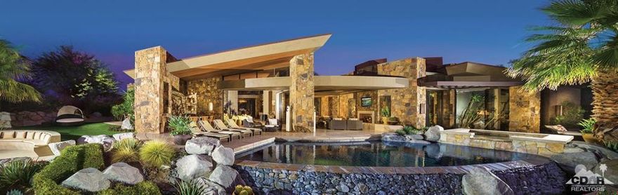 Desert contemporary home designed by architect Kristi Hanson with an elevated homesite offering golf course, a running stream, mountain, and valley views.The gated property opens into lush landscaping w/on site parking. An open floor plan with pocket sliders providing seamless indoor/outdoor transition. The great room w/vaulted wood ceilings opens to the gourmet kitchen, wet bar, and a dining room w/curved glass that cantilevers over a courtyard water feature. A beautiful double-sided fireplace can be seen from all areas of the living space. The spacious master retreat features floor-to-ceiling glass, a stone fireplace, built-in television with a gorgeous spa-inspired his and her bathroom. There 3 guest suites (one is currently furnished as an office) including a detached casita. The expansive patio offers panoramic views,water feature flowing into saltwater pebble-tec pool/spa, firepit lounge, outdoor living room w/fireplace, sunbather's deck, dining area, sit-up bar w/tv, and BBQ.