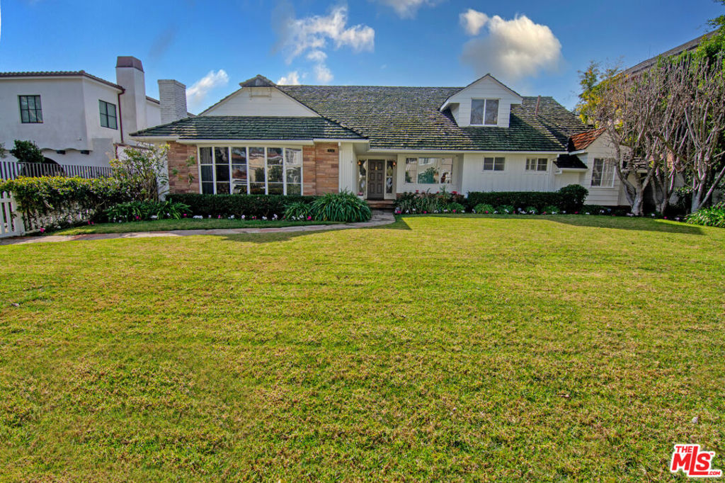 Located in the Flats of Beverly Hills on one of the most desirable streets, is a rare opportunity that seldom comes available. First time on the market in close to 60 years, this well maintained, English Traditional home features; 5 Bedrooms, 6 Baths, 4,412 sf on a 16,159 sf lot. A beautiful inviting entry foyer leads you to all areas of the home. The formal living room has a cozy fireplace and overlooks the sizable front yard with a story-like white picket fence. A large formal dining room is situated perfectly adjacent to the kitchen with breakfast nook. The wonderful family room is a welcoming central area of the home, complemented with a bar, impressive stone fireplace, vaulted ceilings, lovely built-in book display and provides access to the loggia and sprawling back yard. The first level offers 3 bedrooms plus a maid's quarters with the entire second story dedicated to the primary bedroom suite offering high beamed ceilings, fireplace, generous closet and dressing areas, balcony, and a large office. Truly an extraordinary lot in a prime location. Within close proximity to the Beverly Hills Triangle and a multitude of the best restaurants and shopping Beverly Hills has to offer.