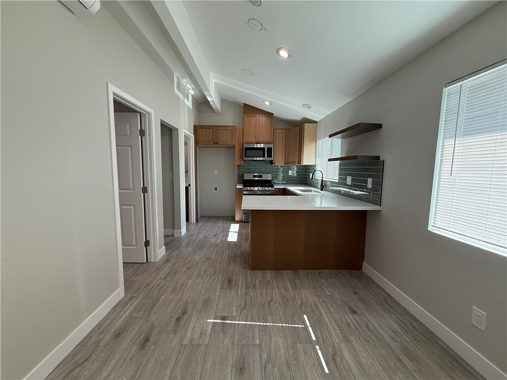 Just completed brand new junior ADU attached to the main house with separate entrance. This cozy space features high ceilings with a small living room, a beautiful kitchen with peninsula island seating, modern cabinets with lots of storage, stainless steel stove and microwave hood vent, and large sink. Flooring is all tile for easy maintanance. The bedroom has a nice size closet space with its own minisplit AC unit. The bathroom has a standing shower with modern tile and fixtures, large vanity, and high ceilings. There is a closet space for a stackable washer & dryer unit. Utilities included in the rent includes: electricity, gas, and water! The entire property features a long driveway for parking, as well as plenty of street parking that is never full. Beautiful unit in a great location of Garden Grove!