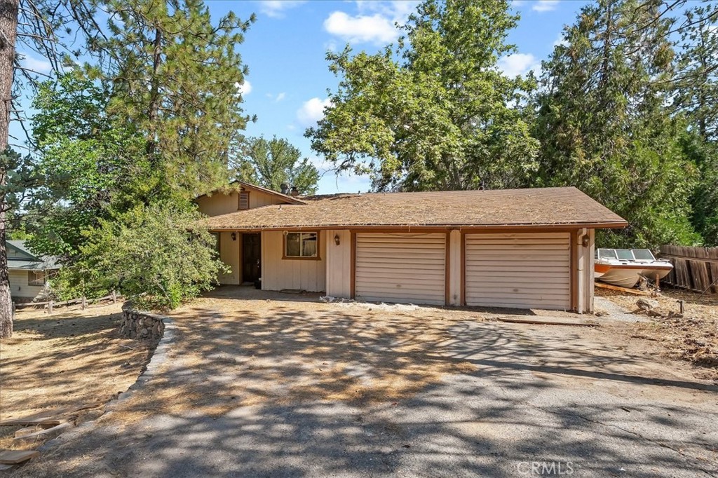 Great first time buyer or investor home! The Royal Oaks subdivision location is close in town to all of the convenience of shopping, doctors and schools. This 3 bedroom, 2 bath diamond in the rough has a spacious living area with neat center round fireplace, large kitchen with room for more cabinets, a built-in hutch or custom breakfast bar. From the dining are there is a slider to back patio. Guest bedrooms and a guest bathroom with bathtub are down the hall. The big primary bedroom has a walk-in closet and an adjoining bathroom with shower. Usable flat back yard with fenced/patio deck area in a great spot to enjoy the shade from tall trees. 2 car attached garage with separate bays, side yard for additional parking space, a shed and a storage/workshop space is under the house. This location also lends itself to going for easy walks on the roads and not too busy with vehicles so kids can ride their bikes.