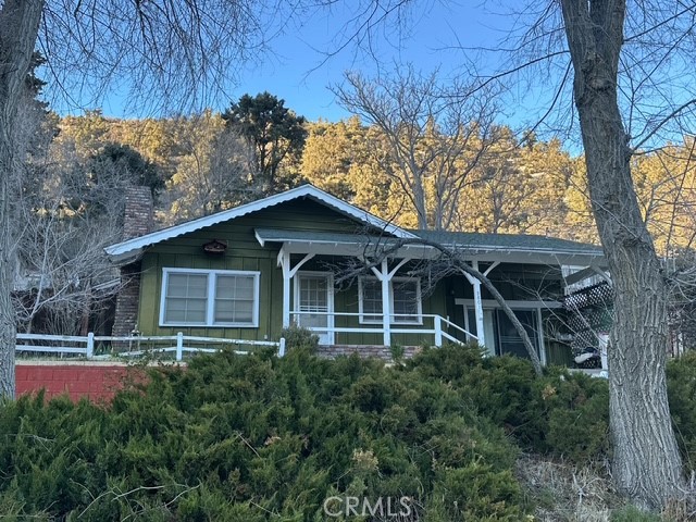 Charming Frazier Park home that is on the sunny side of the town. Mountain views all around. This home features 2 nice size bedrooms and two bathrooms, with a bonus room that could serve as a third bedroom or perhaps a den or office. Home has new vinyl flooring. Property is off a paved road and just minutes from the freeway. The living room has a beautiful brick fireplace for those cozy winter nights. The beautiful knotty pine cabinets give it real country charm. Looking for a getaway or a nice starter home only 30 minutes from Santa Clarita, this is a great place. There is a workshop/storage/craft room off the laundry room. The back bedroom has a door out to the patio area. Good size closets and rooms are large enough for king sized beds. You won't want to miss this home, priced to sell. Walking distance to shopping and restaurants. Reduced! Run don't walk.