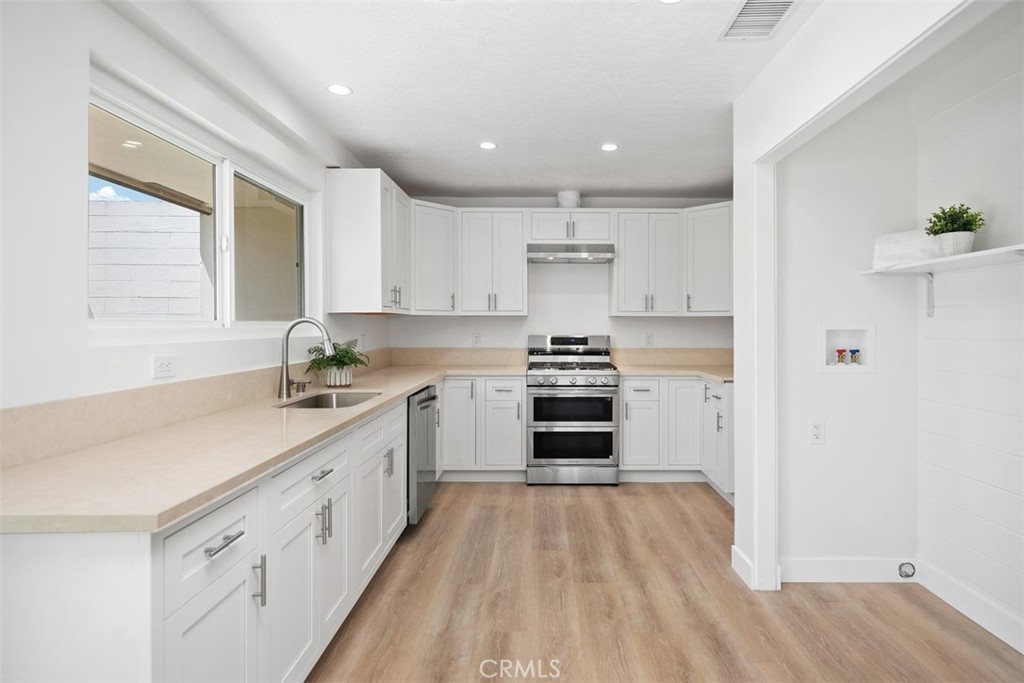 Beautifully renovated 2 bed, 2 bath home in the peaceful 55+ San Juan Hills West community. This move-in ready residence features all-new luxury vinyl plank flooring, fresh interior paint, and abundant natural light throughout. The completely updated kitchen boasts elegant white shaker cabinets, quartz countertops, and an open layout flowing into the living and dining areas, highlighted by a charming custom plaster fireplace. The spacious primary suite offers two large closets and a luxurious ensuite with a walk-in shower and double vanity, while the guest bedroom includes its own closet and easy access to a full guest bathroom. Enjoy two private patios—one off the kitchen/living area, perfect for entertaining, and another off the bedrooms for quiet relaxation. Additional highlights include all-new LED lighting, central air conditioning, and a laundry area with washer/dryer hookups. Conveniently located near the community pool, San Juan Hills Golf Club, and just minutes from dining, shopping, and historic downtown San Juan Capistrano.