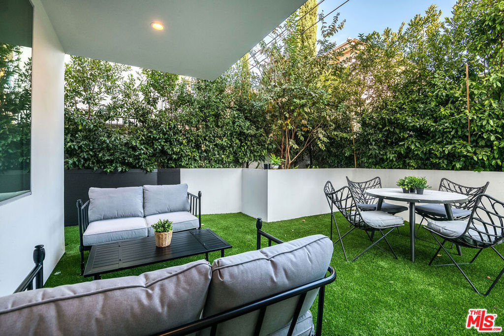 Spacious and fully furnished 1BD/1BA Apartment with rare private backyard in prime Beverly Grove. This well-appointed unit features an open layout with high ceilings, hardwood floors, and direct access to a large private patio from the living room. Modern kitchen with quartz countertops, stainless steel appliances, and custom cabinetry. The oversized bedroom includes a walk-in closet, and the large bathroom offers a soaking tub and glass-enclosed shower. Includes in-unit laundry, central A/C, controlled access, and two gated parking spaces. Located on a quiet, tree-lined street near The Grove, Erewhon, Melrose Place, and top dining and shopping.