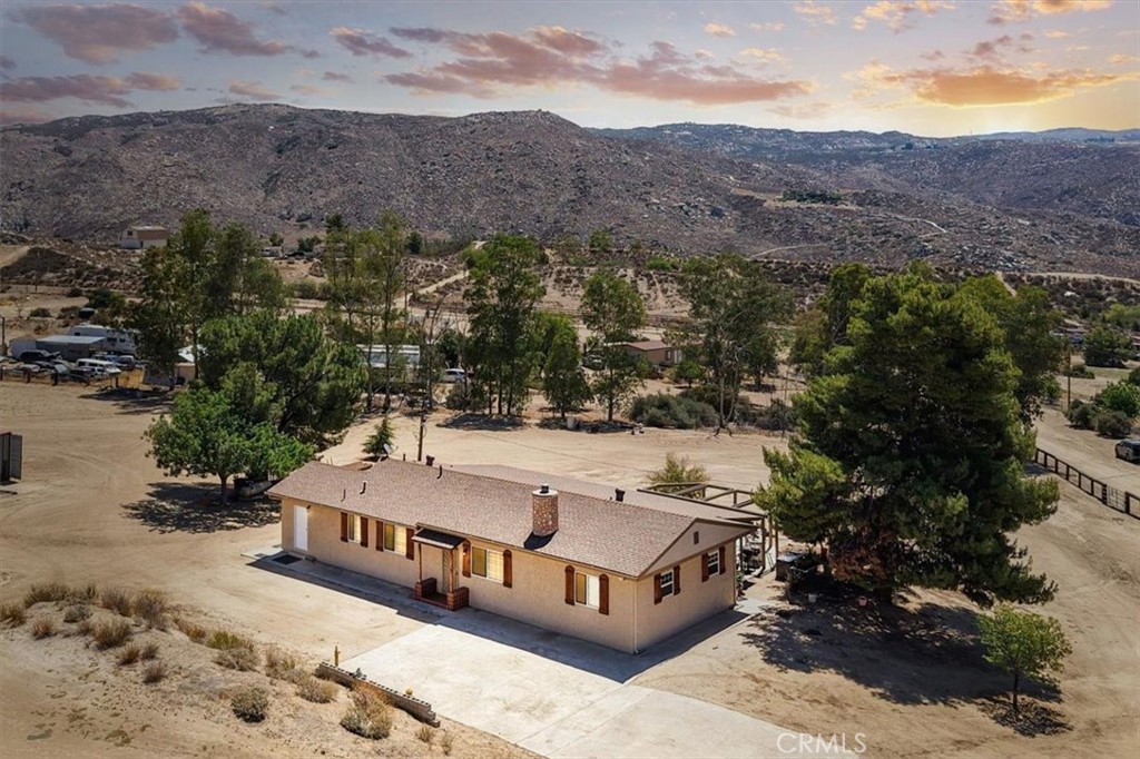 Welcome to your new Ranch Home! Enjoy the 4 acres of nearly flat, cleared, useable land by entering through the automatic security gate, which is part of a fully fenced property. This custom-built 2 bedroom home can be your own slice of heaven with its peaceful and quiet surroundings. The living room has a real wood fire stove to warm and provide the serenity of fire crackling in the winter. The dining room has a built in solid oak hutch and glass windows. The kitchen is equipped with Corian counter tops, a duel fuel range/oven, and plenty of solid oak cabinets, some with glass doors, for storage. This kitchen has crown molding accents throughout and a breakfast bar next to the sliding patio door. The Corian sink sits below a window facing the entrance to this property. Adjacent to the kitchen is a small breakfast nook area with a wall mounted AC unit for extra cooling. The hall and office have plenty of storage and closet space and the connecting half bathroom and laundry room. At the end of the hall is an office. Next are the 2 bedrooms each with a large closet. One bedroom has its own exterior door. The centrally placed full featured bathroom comes with all of your standard features. From the outside covered patio you'll enjoy a wonderful mountain view, and a completely furnished BBQ island. This horse property has lots of open space for whatever you would like to do. There are 2 corrals and a round pen for training. There is also a workshop with 220V and a covered service area and a storage shed. At the end of the property between the 2 corrals is a Tough Shed for most all of your yard equipment storage needs. Don't forget to look around and you will find a variety of mature fruit trees. Finally, you will discover an outlined and finished space for an RV. This space has water and power hook-up for convenience. This ranch home also includes a power generator that can run the Water Well, the Whole House, the Front Gate, and the Small AC Unit in case of a power outage. Schedule your tour today to see this amazing ranch home!