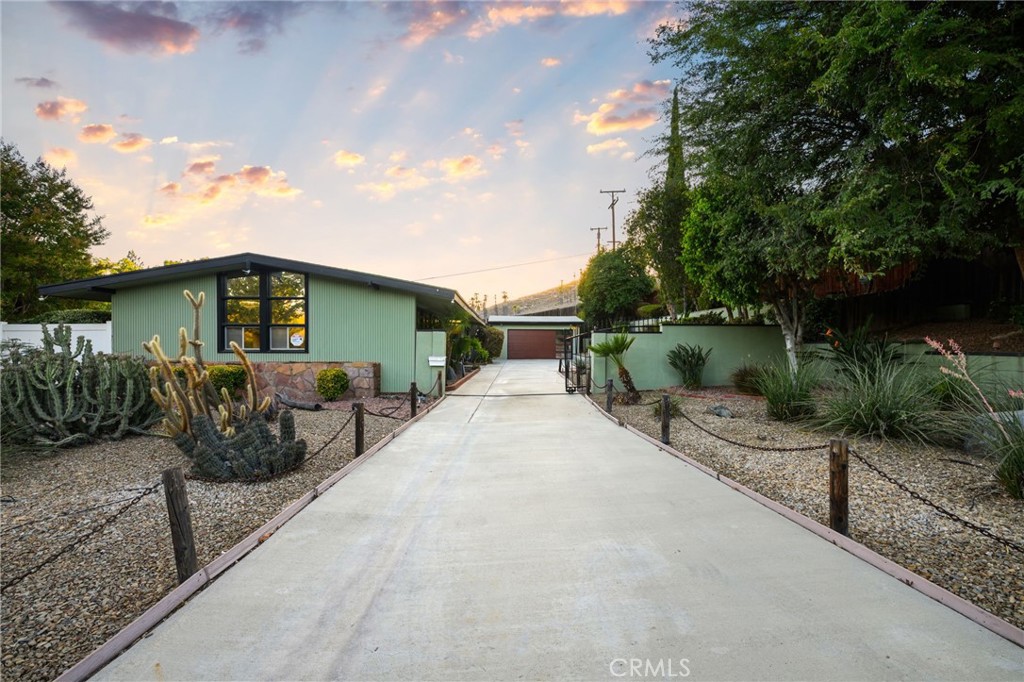 Welcome to this classic mid-century gem in the highly sought-after “Cowboy Streets.” This 3-bedroom, 2-bath home sits on an expansive 12,197 sq. ft. lot and includes a two-car detached garage. Inside, you’ll find brand-new carpet and fresh interior paint, creating a move-in-ready space with timeless character. The home’s design showcases the best of mid-century architecture with clean lines, walls finished in vertical clear fir wood, and a striking fireplace as the focal point. Hidden shelving and built-in storage are thoughtfully integrated throughout, including a custom bookcase in the family room. The galley kitchen blends retro charm with functionality, featuring a gas cooktop, oversized range hood, indoor grill, oven, and a central island. Large windows bring in natural light while connecting the indoors with the low-maintenance desert landscaping outside. For relaxation and wellness, the home also includes a private sauna room—perfect for unwinding at the end of the day. Additional features include a gated entry, security cameras, and a spacious backyard with endless potential. The home is conveniently located within a mile of Alcott Elementary, Gage Middle, and Polytechnic High, and just minutes from the 91 freeway, downtown Riverside, CBU, RCC, and UCR. Don’t miss the chance to own a piece of mid-century history in one of Riverside’s most desirable neighborhoods!