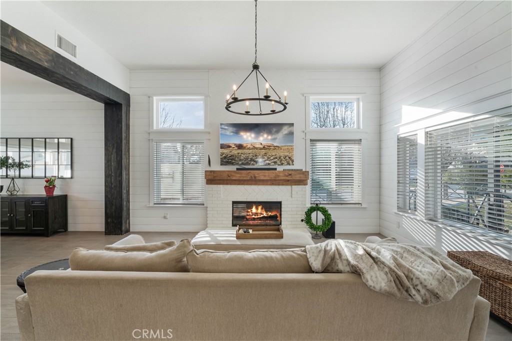 This home covers all the bases! Located in Vintage Valley Estates, this remodeled two-story offers RV parking with hook-ups, an in-ground pebble-tec pool with a baja shelf and spa, and a covered patio with fans, artificial grass, pavers, and landscaping—perfect for year-round entertaining. Inside, the first level features a living room with 18’ vaulted ceilings, a fireplace, shiplap siding walls, and custom wood beams. A formal dining room leads into a modern yet elegant kitchen with Alder wood cabinets, quartz countertops, a custom tile backsplash, and commercial-grade appliances. Also on the main level is a bedroom with a bath and an outside entrance, ideal for a mother-in-law suite or guest unit, along with a half bath and laundry room. Upstairs, the primary bedroom suite boasts a city lights view, a fireplace, and an en suite bath with a custom walk-in shower, dual vanities, a soaking tub, and a walk-in closet. This level also includes a bonus/recreation room, three bedrooms, and a hall bath. Additional amenities include an expansive driveway leading to a three-car garage with built-in cabinets, finished drywall, and epoxy floors, plus a 50-amp RV electric service. A covered brick porch offers stunning mountain views. Ideally located north of the 210 freeway near major shopping centers, schools, Ontario International Airport, and employment hubs. HURRY BEFORE IT'S SOLD!