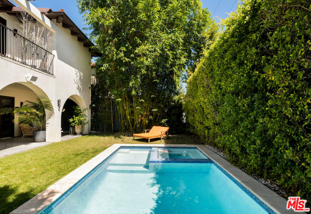 Privately tucked away behind lush, mature landscaping is this contemporary Mediterranean masterpiece in the heart of Beverly Hills. A dramatic archway welcomes guests through the double height front door and into the formal living room displaying a cozy stone fireplace. One of the five bedrooms is placed just off of the living room, offering endless options of additional uses such as an office or exercise room. Coffered ceilings ornately line the formal dining room and den, providing a touch of sheer elegance. The chef's kitchen boasts stainless steel appliances, an abundance of cabinetry for storage, and marble countertops and center island. The grand, wrought iron, staircase is the focal point, gracefully leading to the second level. Luxurious primary suite features an expansive walk-in closet with built-in's and opulent en-suite showcasing dual sinks, stand alone tub, and a generous shower. Three additional bedrooms, each generous in size, with their own en-suites and a laundry room make up this level. Accordion doors seamlessly integrate indoor-outdoor living opening to the covered patio framed by archways and ornate tile rugs. A considerable pool and hot tub meet the flat grassy pad to complete this outdoor oasis. Experience Beverly Hills' finest dining and shops just minutes away from this meticulous abode.