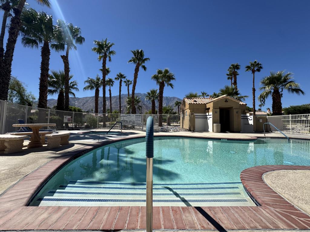 This Palm Springs residence offers comfort and style across 1,588 sq. ft. The single-story layout encompasses three bedrooms and two bathrooms. Imagine walking into your new home through the tranquil courtyard, complete with a water fountain and palm trees, to get the sensation of your personal oasis. The heart of the home is an open-concept living area, featuring a cozy fireplace and sliding glass doors that seamlessly connect to the south-facing backyard. The kitchen is well-equipped with wooden cabinetry, granite countertops, and appliances. Throughout the home's common areas, large windows and custom window coverings allow for natural light to brighten your home. The main bedroom features a walk-in closet with custom-built shelves for ample closet space. Additional features include tile flooring in common areas and a dedicated laundry space. There are low HOA dues, and you own the land. The HOA includes front yard landscaping maintenance. The community offers a refreshing pool with mountain views and a spa. The property's location offers a delightful Palm Springs living experience, complete with palm tree views from select windows, proximity to the I-10 freeway, Palm Springs Aerial Tramway, and the famous Downtown Palm Springs, including shops, restaurants, and museums. Come be a part of where the magic happens.